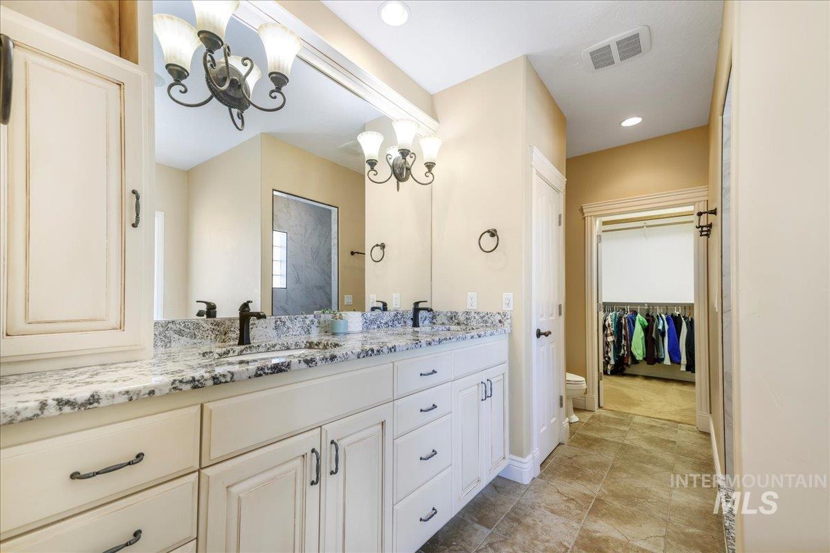 Bathroom with double vanity and a chandelier