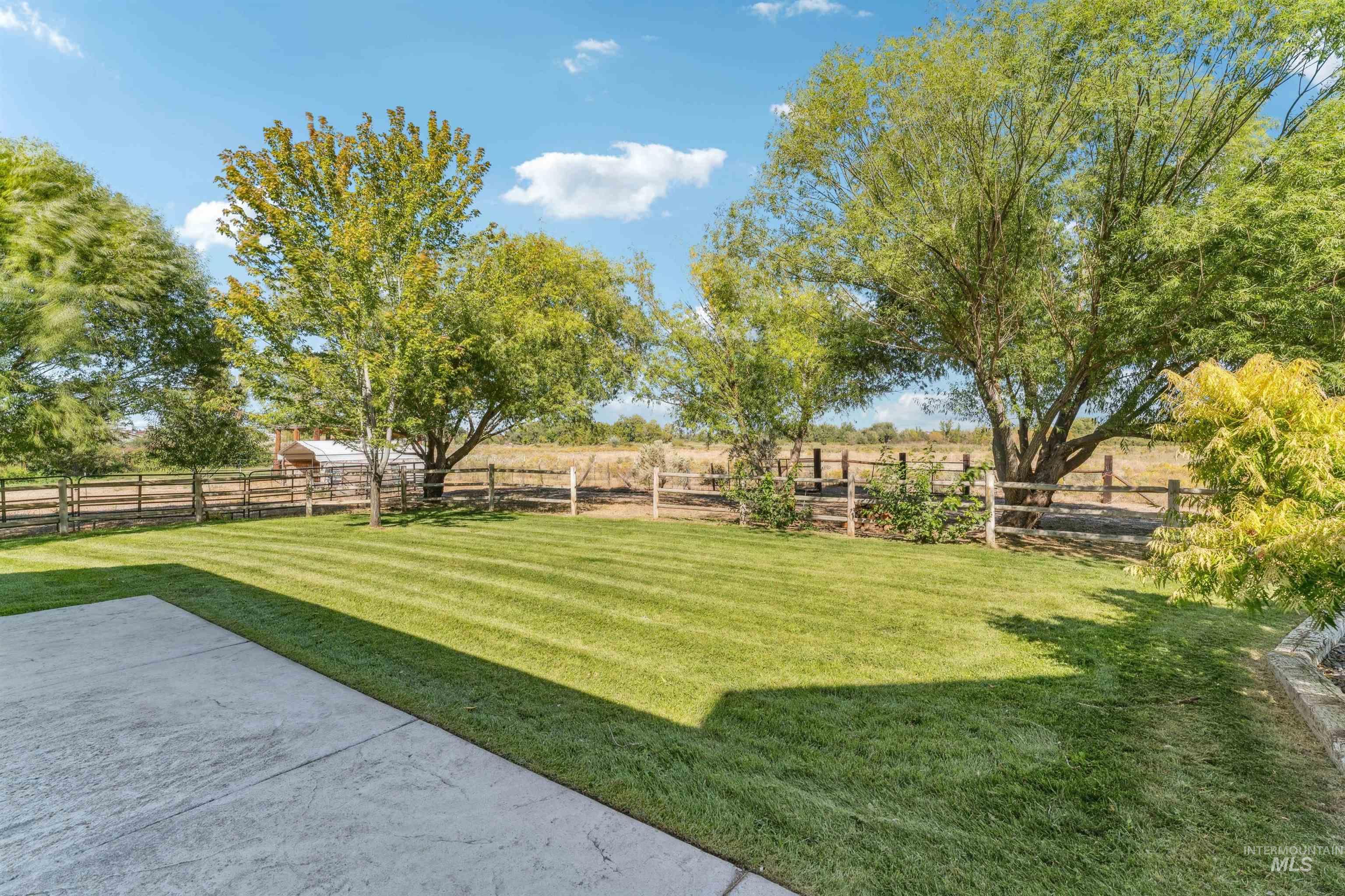 Fenced backyard with a view of countryside