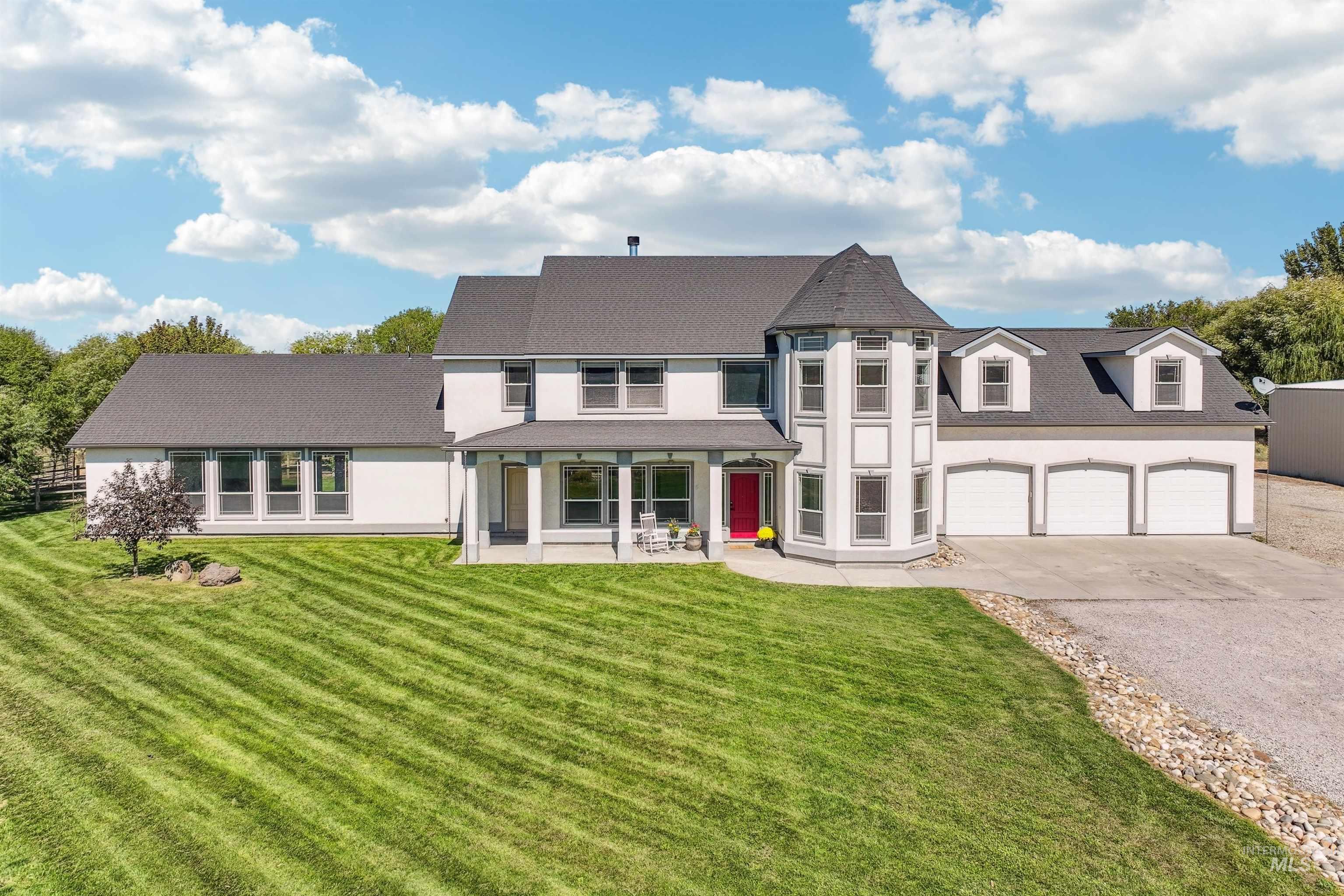 View of front of property featuring a front lawn, stucco siding, driveway, and a garage
