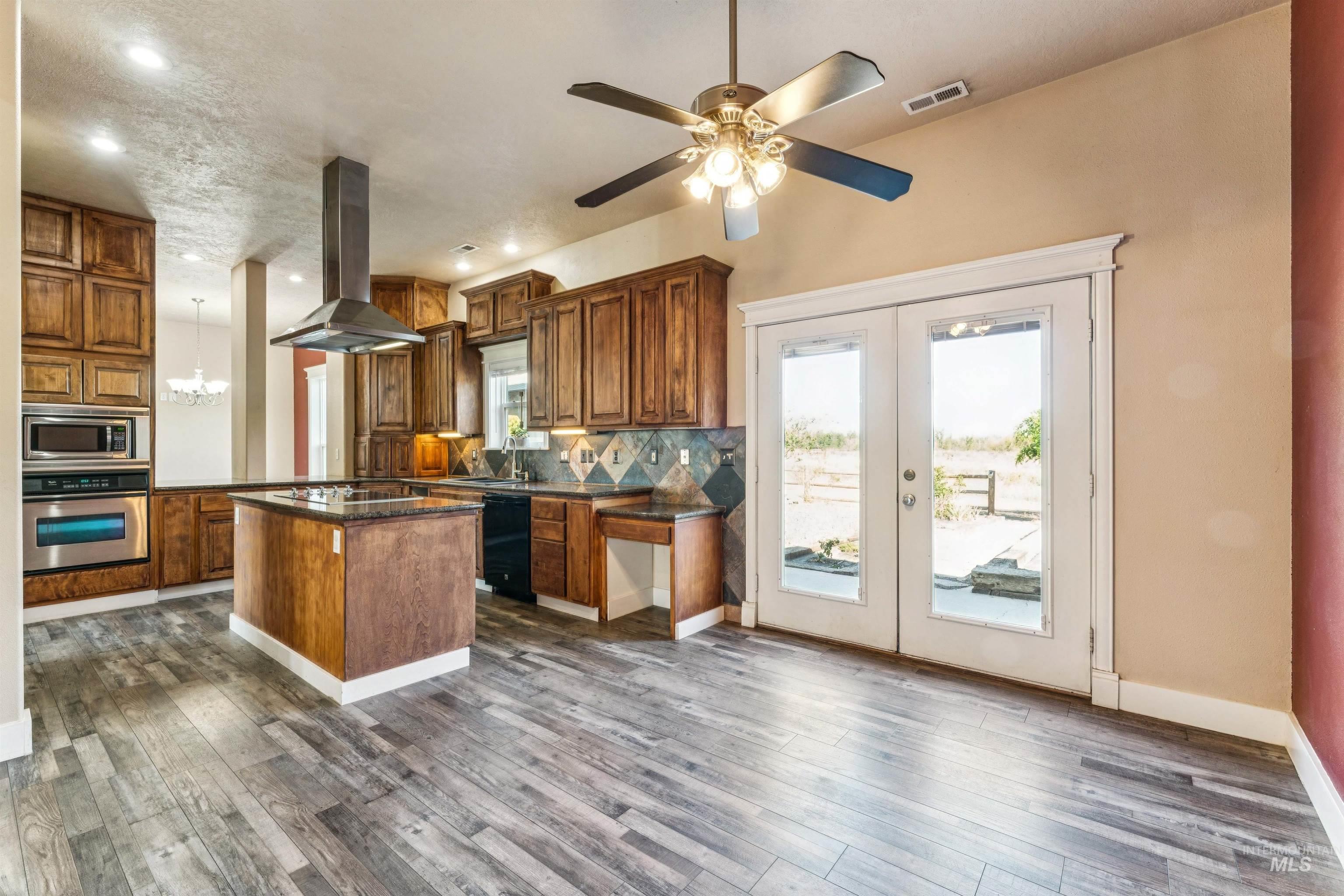 Kitchen with french doors, a kitchen island, tasteful backsplash, stainless steel appliances, and recessed lighting