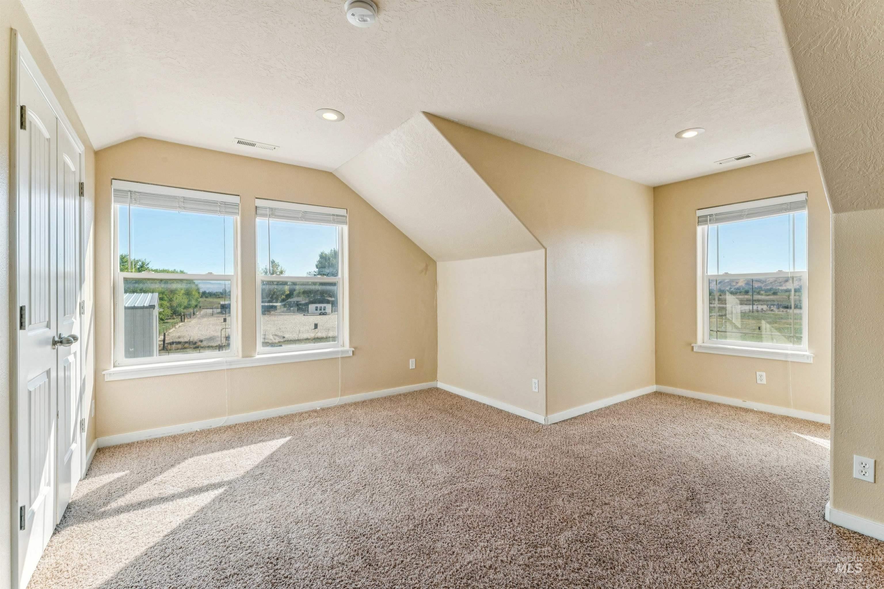 Additional living space featuring lofted ceiling, light colored carpet, a textured ceiling, and recessed lighting
