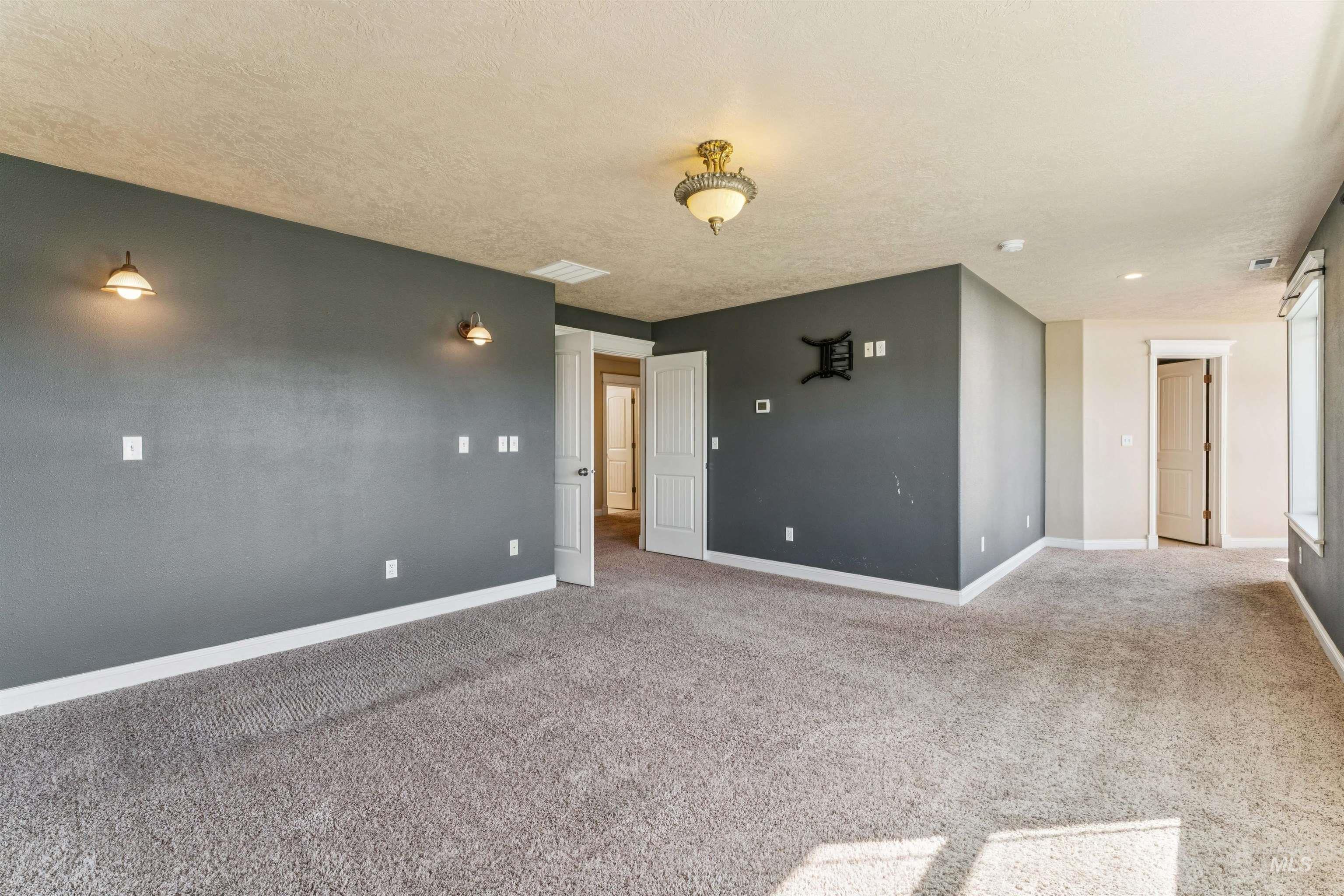 Carpeted spare room with a textured ceiling