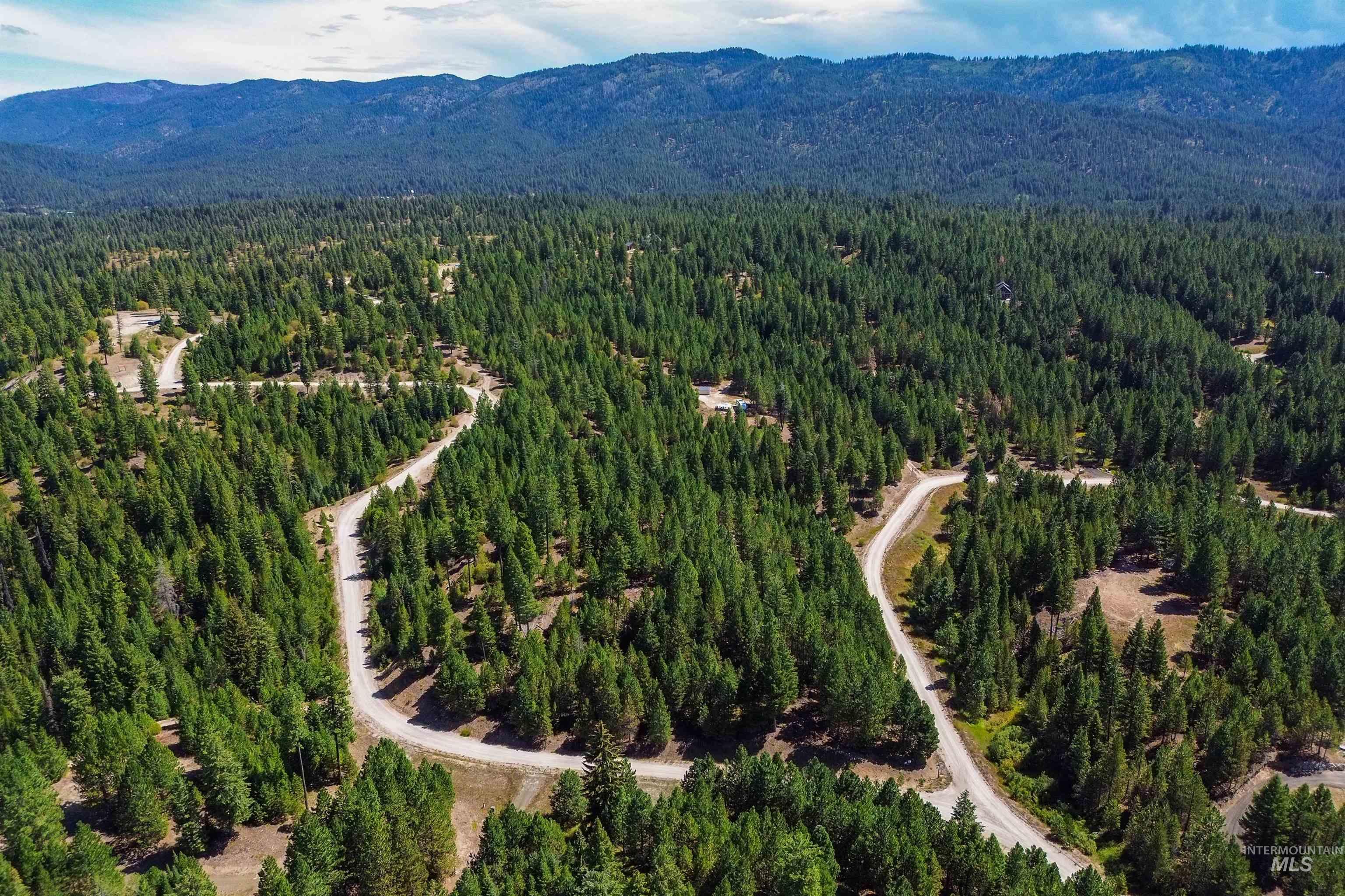 Aerial overview of property's location featuring mountains and a heavily wooded area