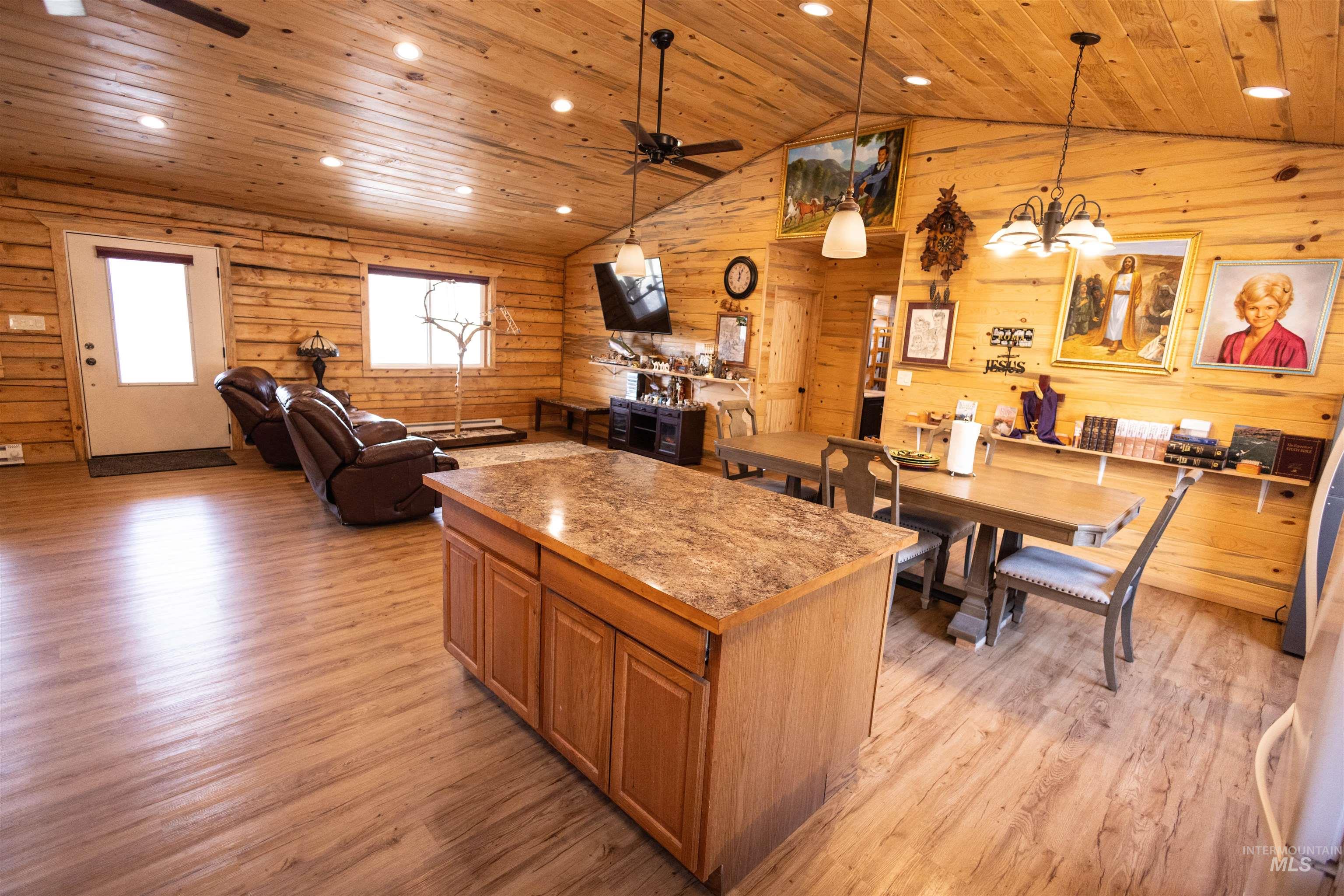 Kitchen featuring decorative light fixtures, light wood-style floors, a center island, open floor plan, and ceiling fan