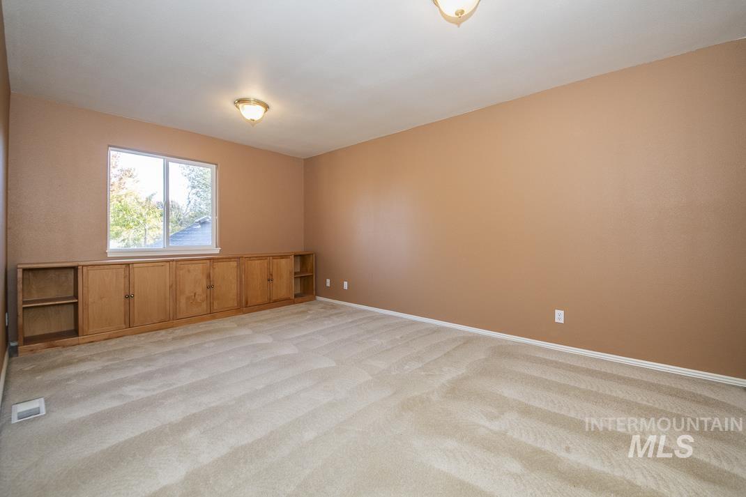 Unfurnished room featuring light colored carpet and baseboards