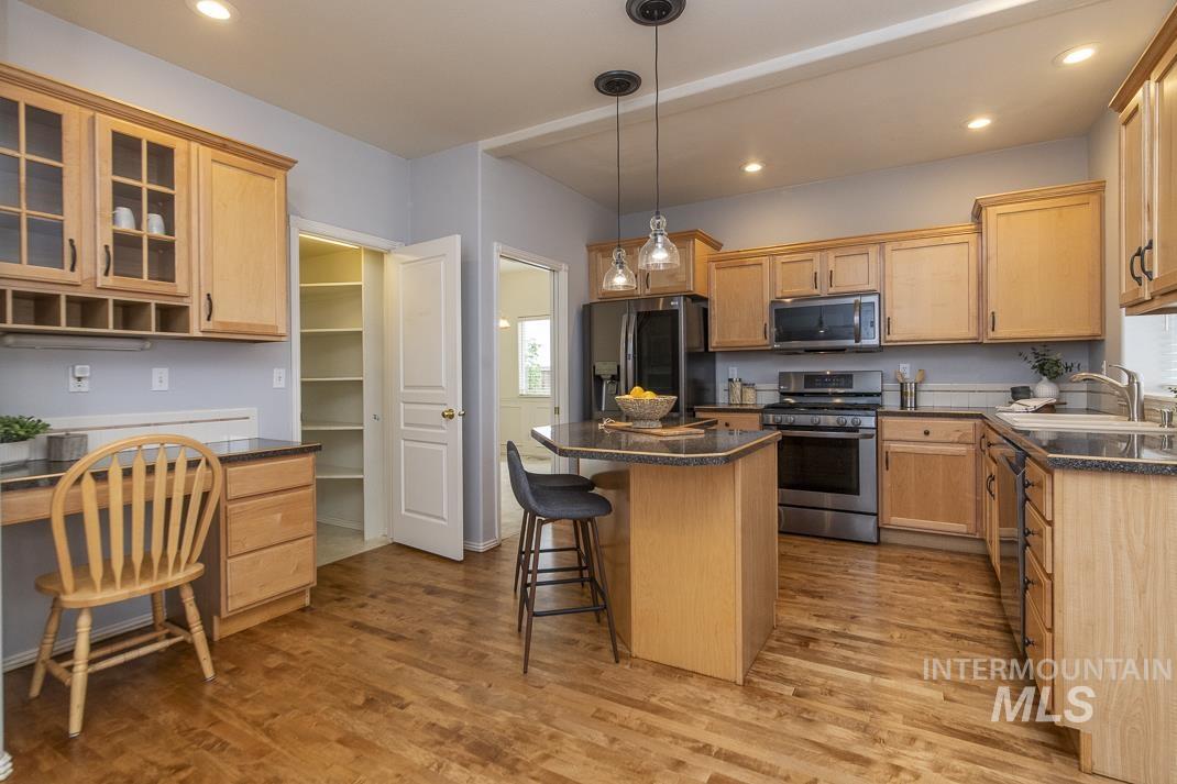 Kitchen featuring stainless steel appliances, a kitchen island, recessed lighting, a kitchen breakfast bar, and built in study area