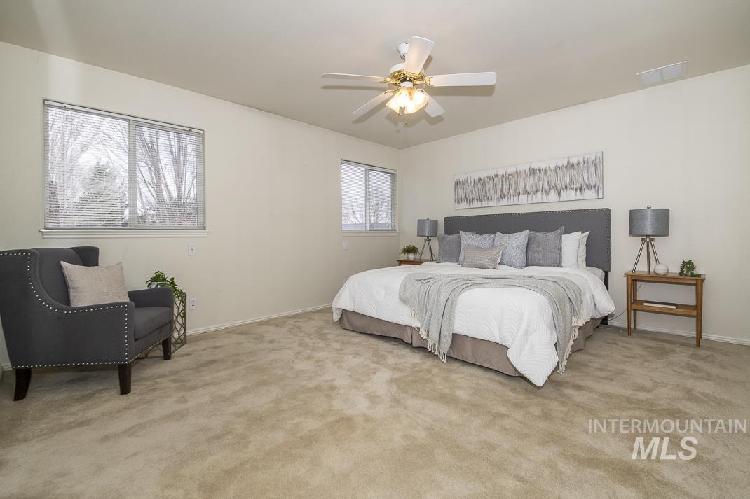 Bedroom with light carpet and a ceiling fan