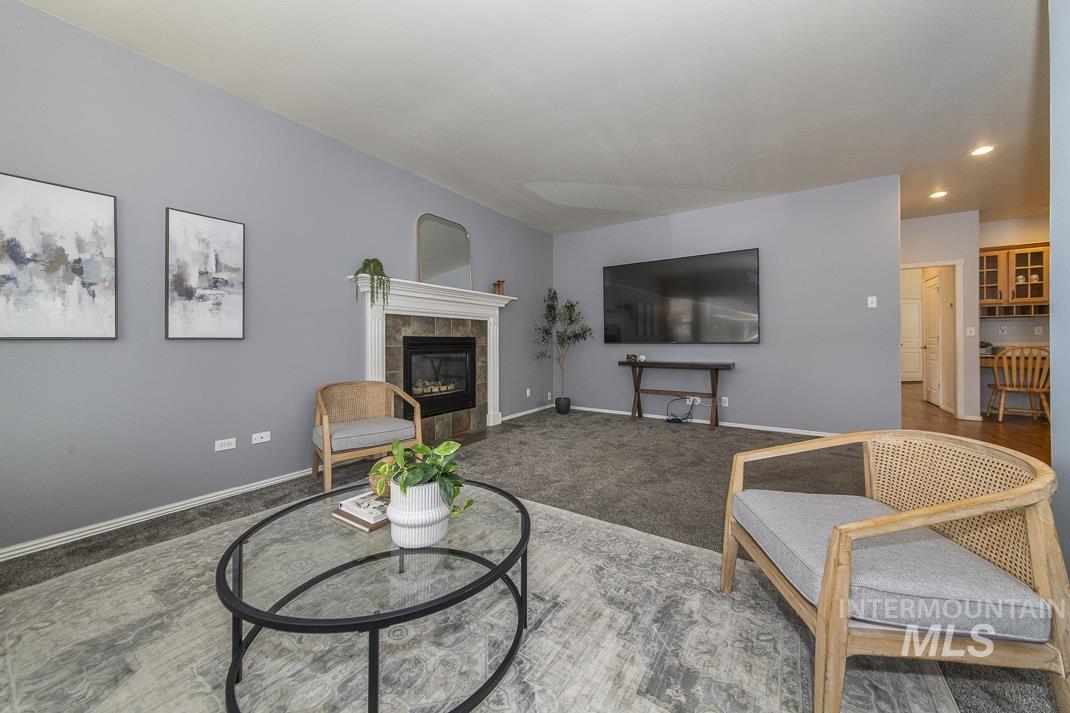 Living area featuring carpet, a tile fireplace, and recessed lighting