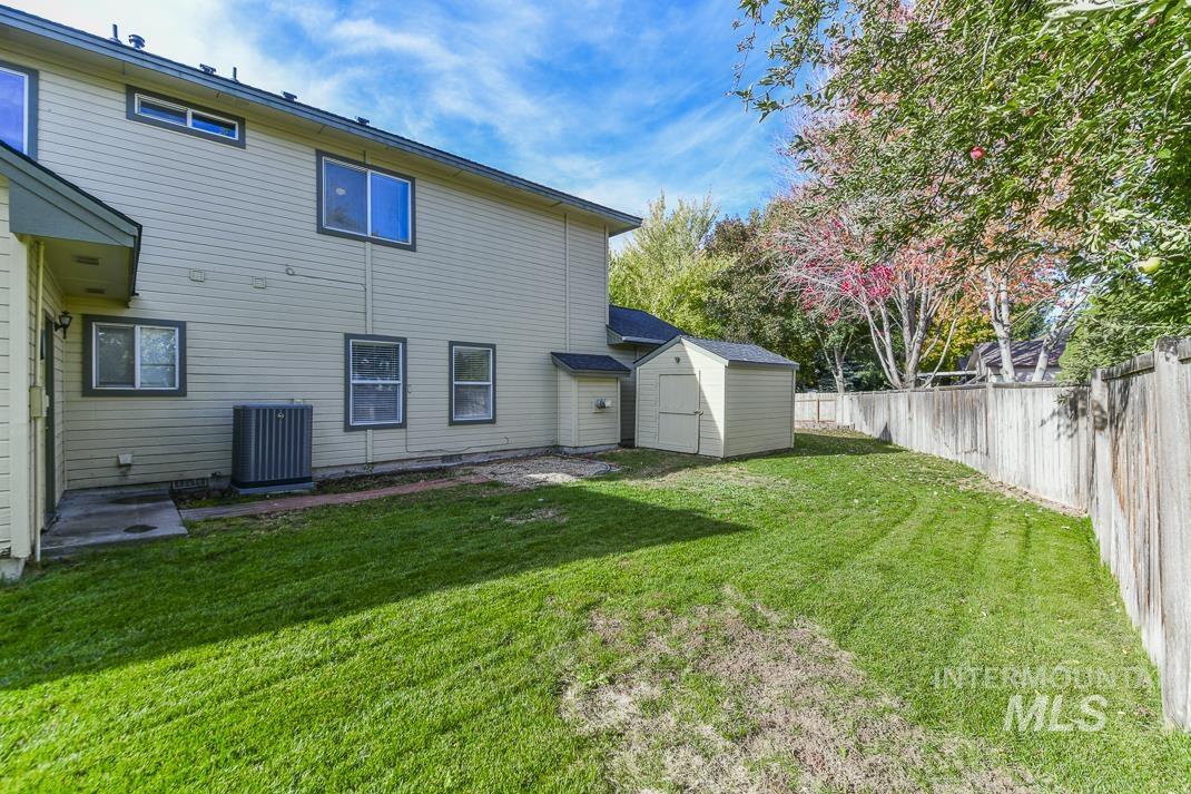 Back of property with a shed, a patio, and a fenced backyard