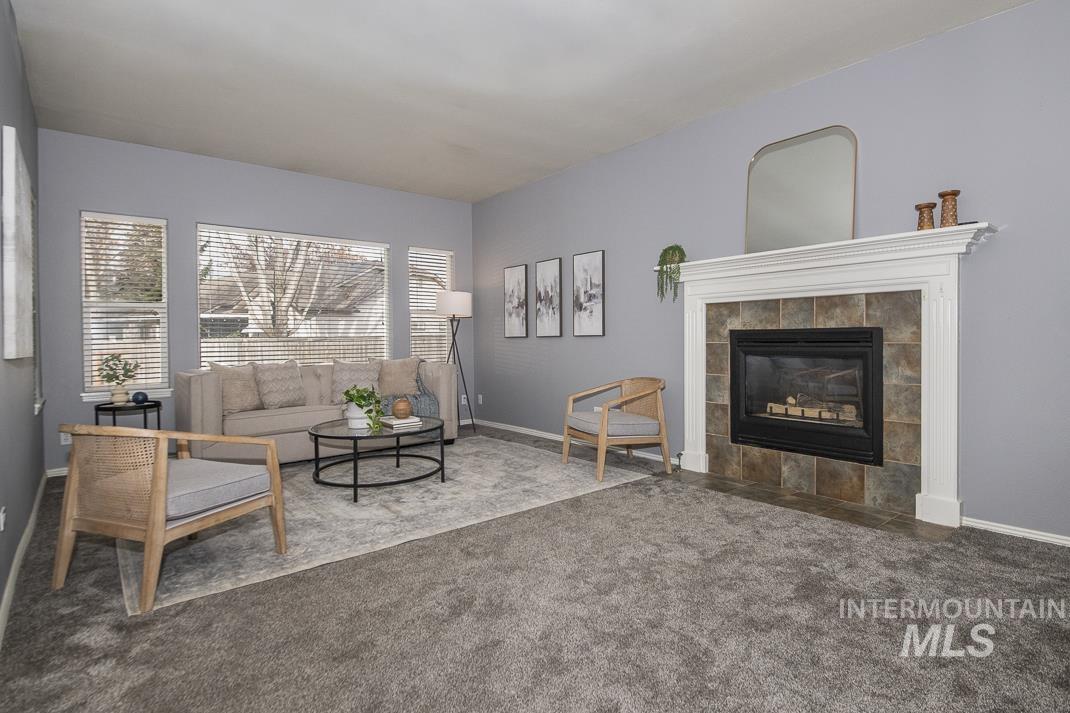Carpeted living area with a fireplace and baseboards