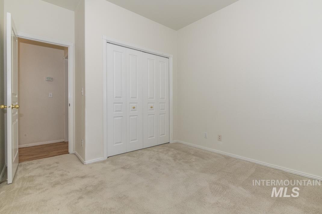 Unfurnished bedroom featuring light colored carpet and a closet