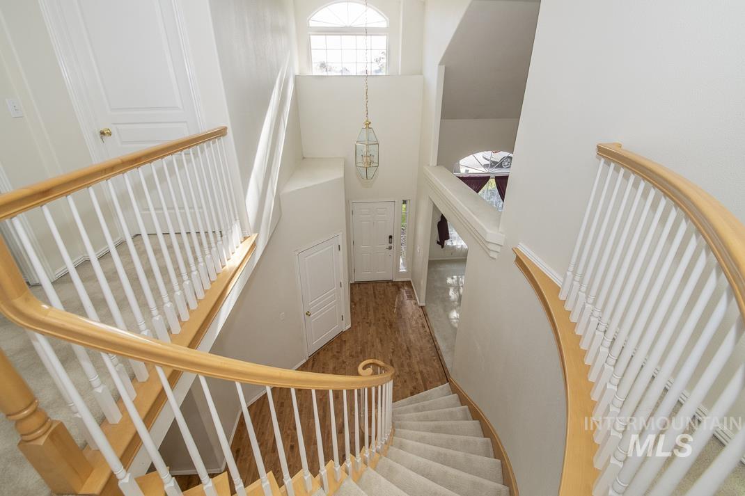 Staircase with a towering ceiling and wood finished floors
