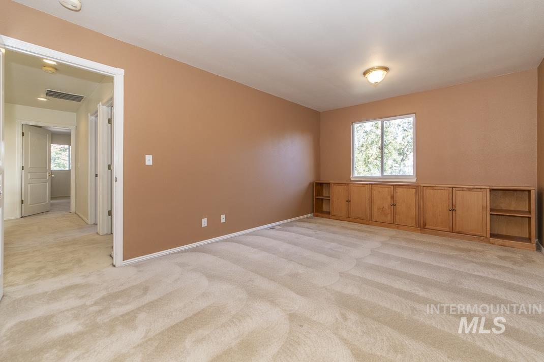 Empty room featuring light colored carpet and plenty of natural light