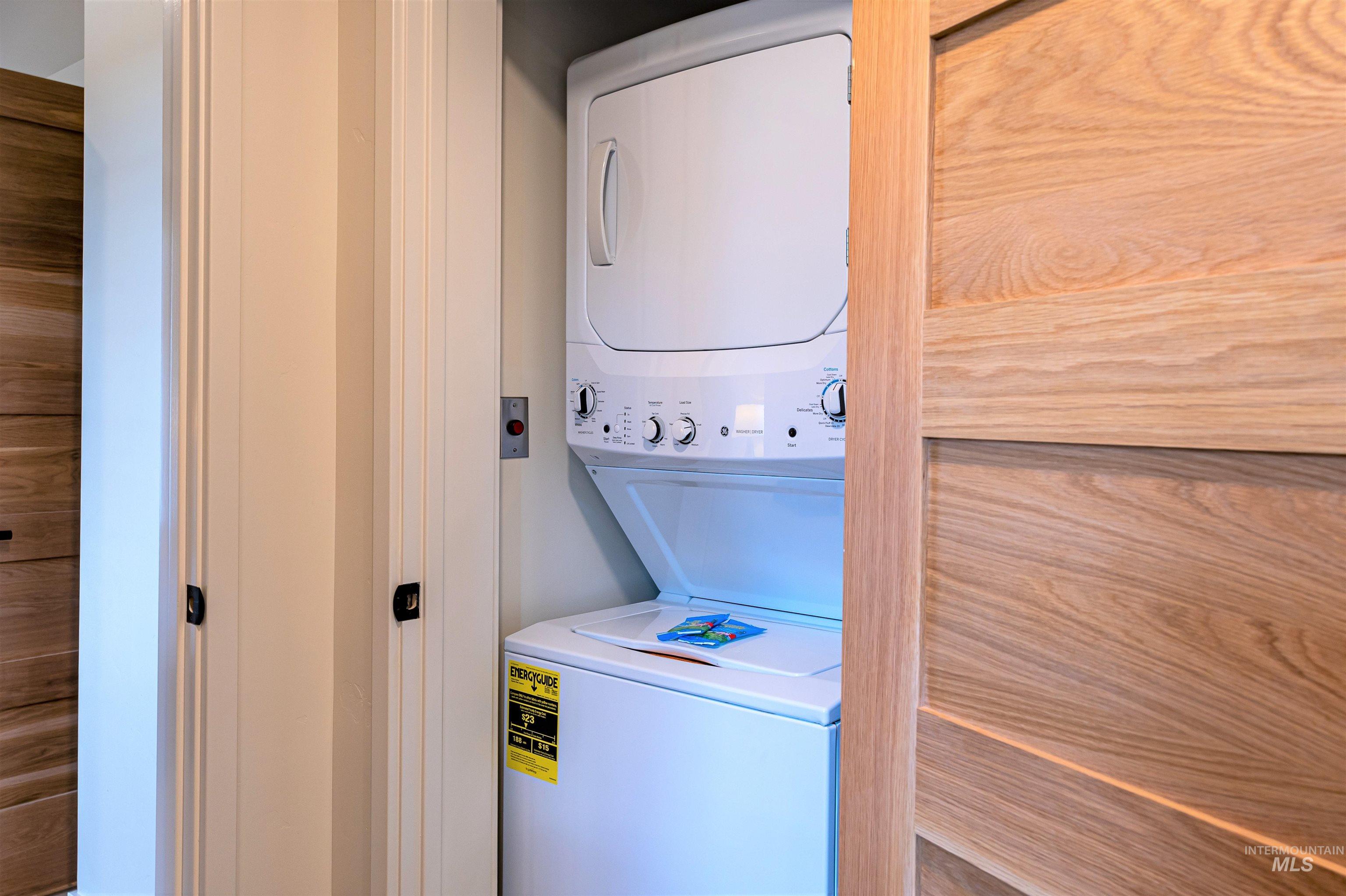 Washroom featuring stacked washer and clothes dryer
