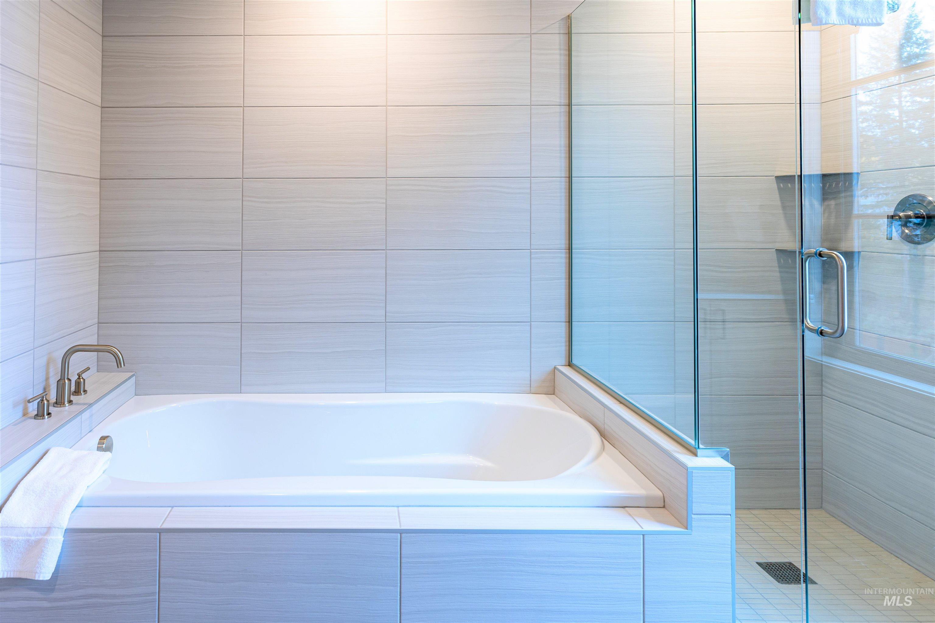 Bathroom featuring a bath and a shower stall