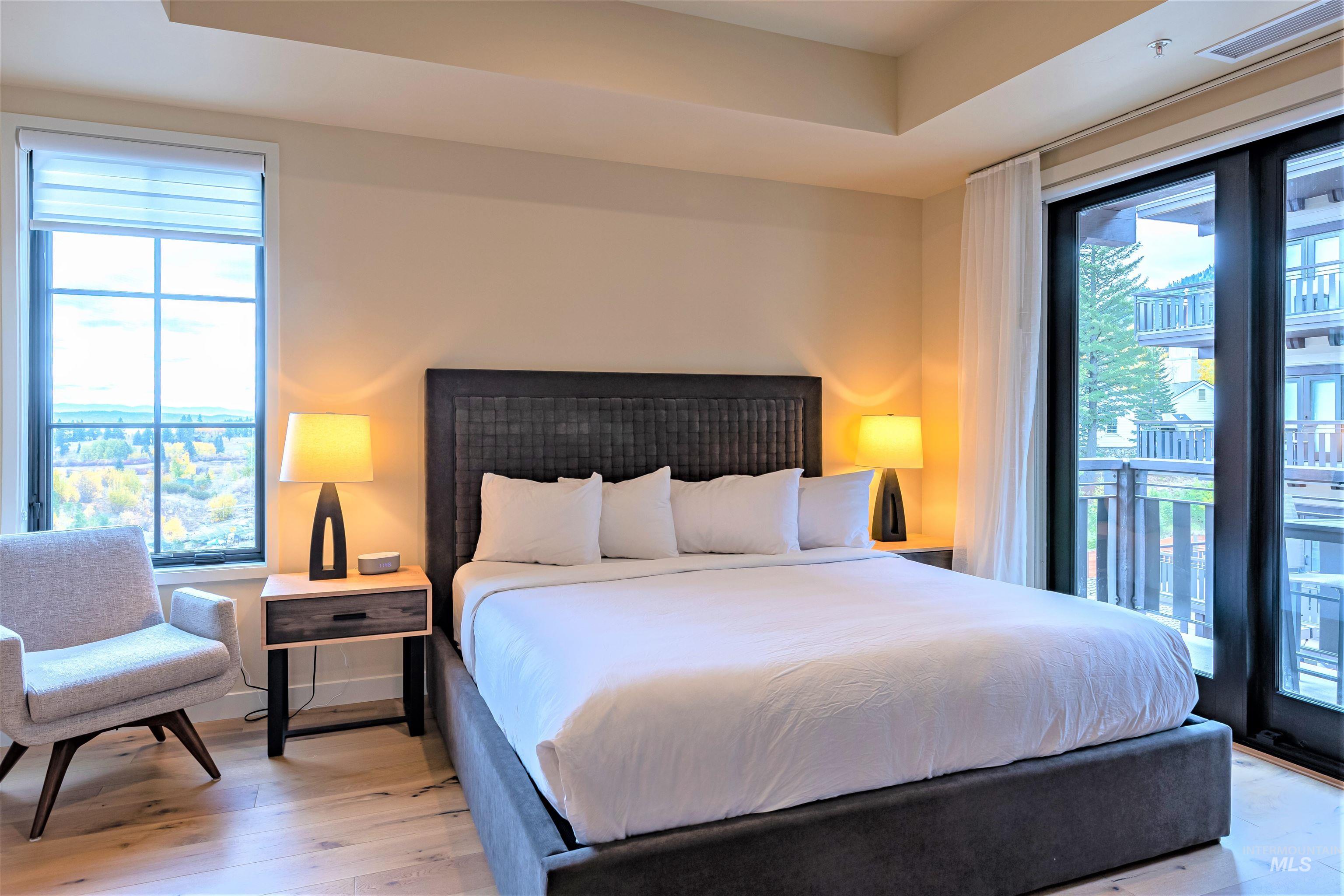 Bedroom with access to exterior and wood finished floors