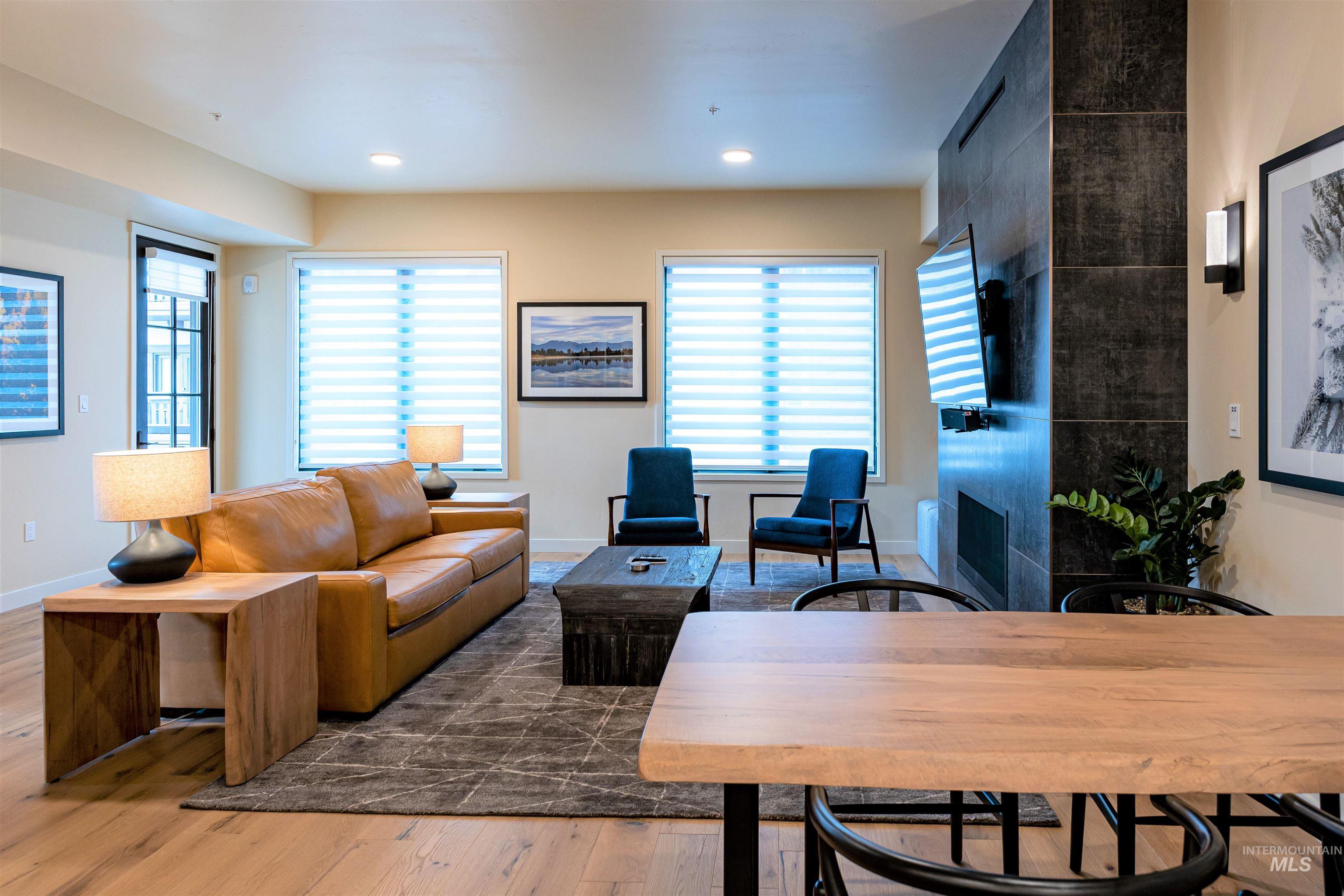 Living area featuring wood finished floors, a tile fireplace, and recessed lighting