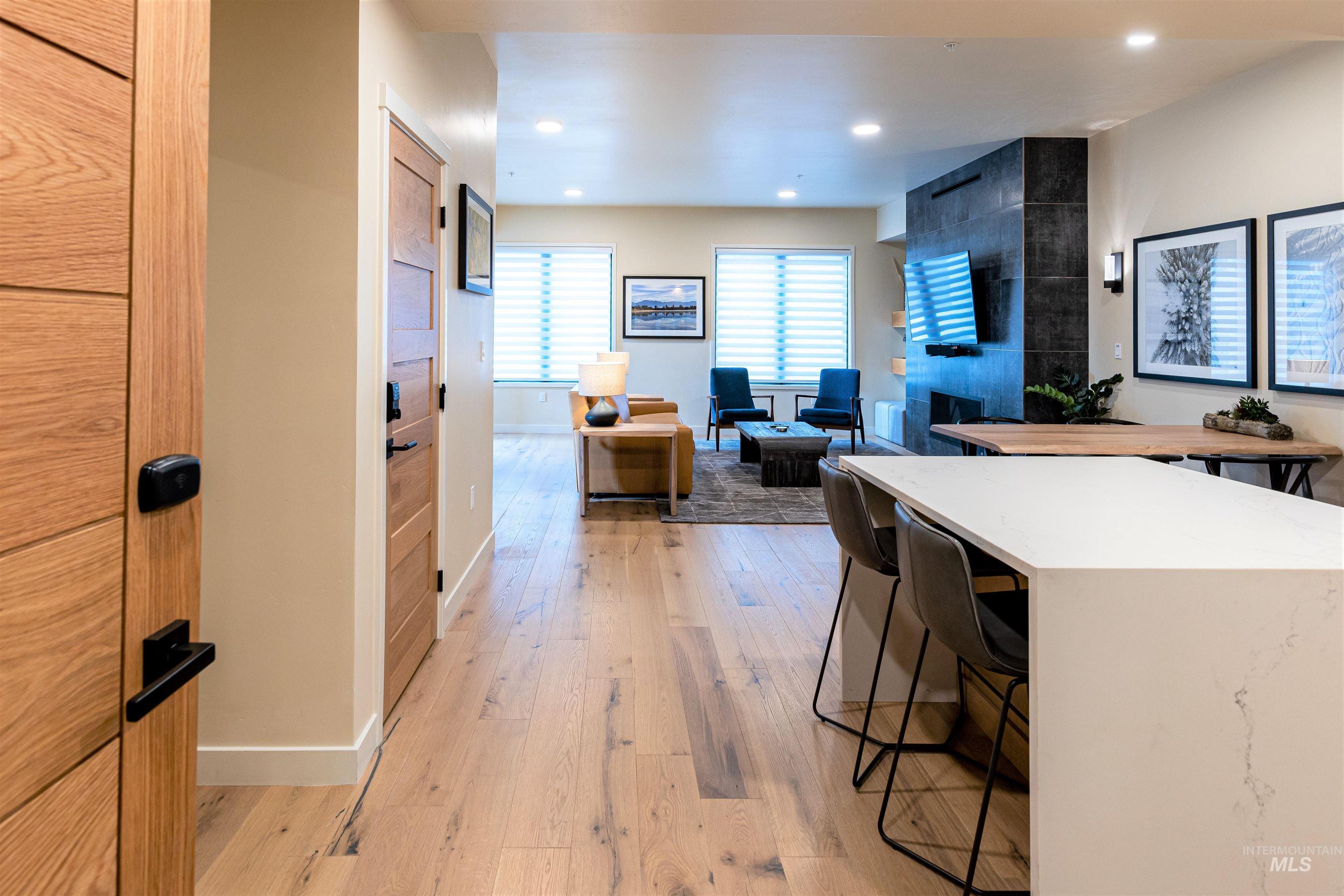 Kitchen with a kitchen bar, light wood finished floors, recessed lighting, a kitchen island, and light stone counters