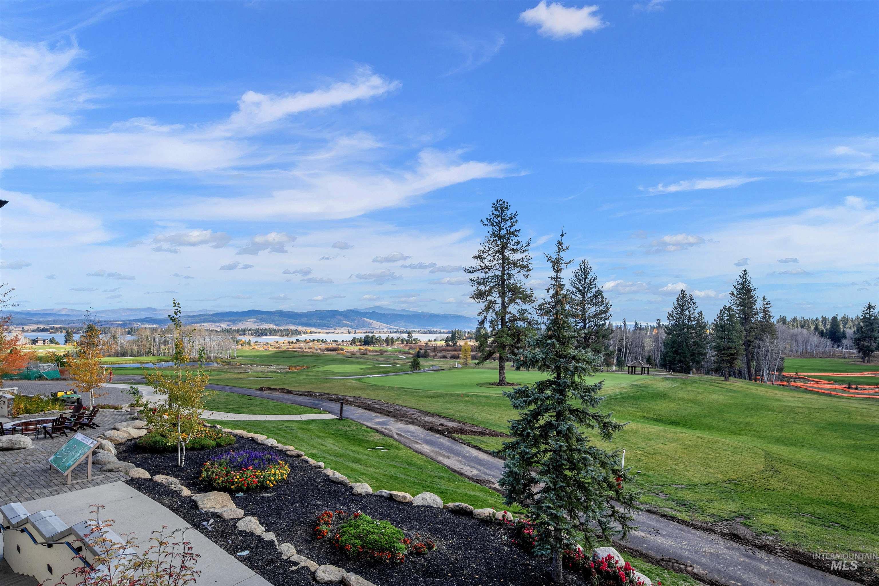 View of property's community featuring a mountain view, a yard, and view of golf course