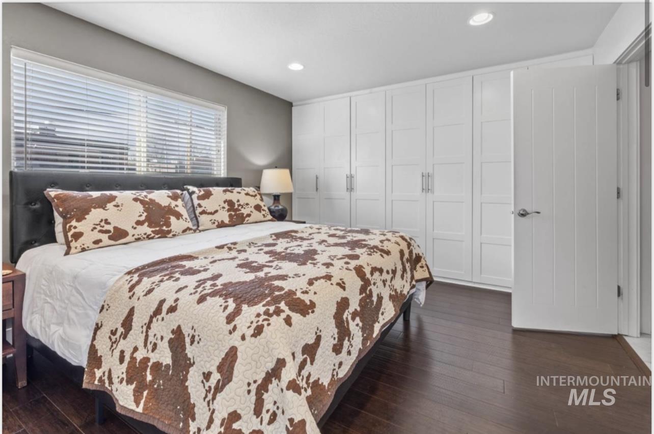 Bedroom featuring dark wood-type flooring, recessed lighting, and a closet