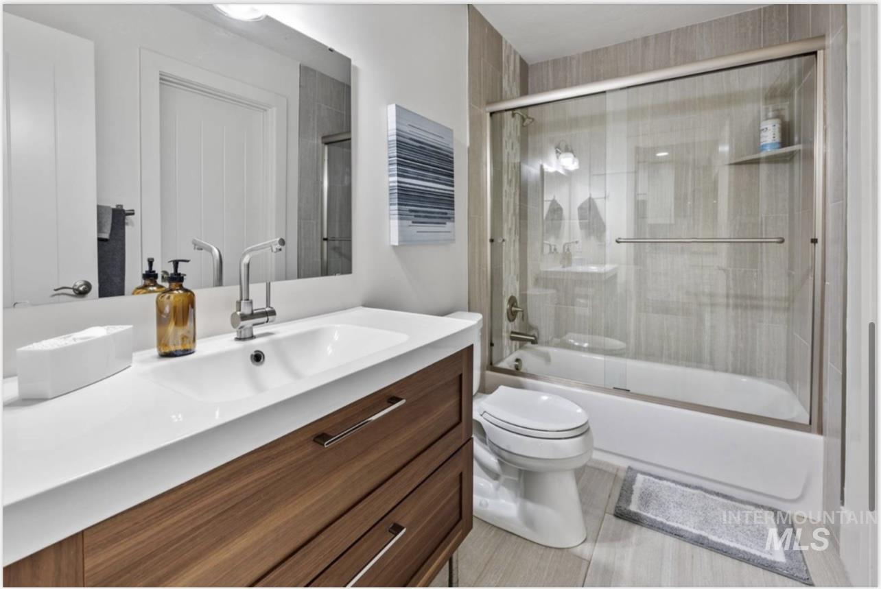 Full bathroom featuring enclosed tub / shower combo and vanity