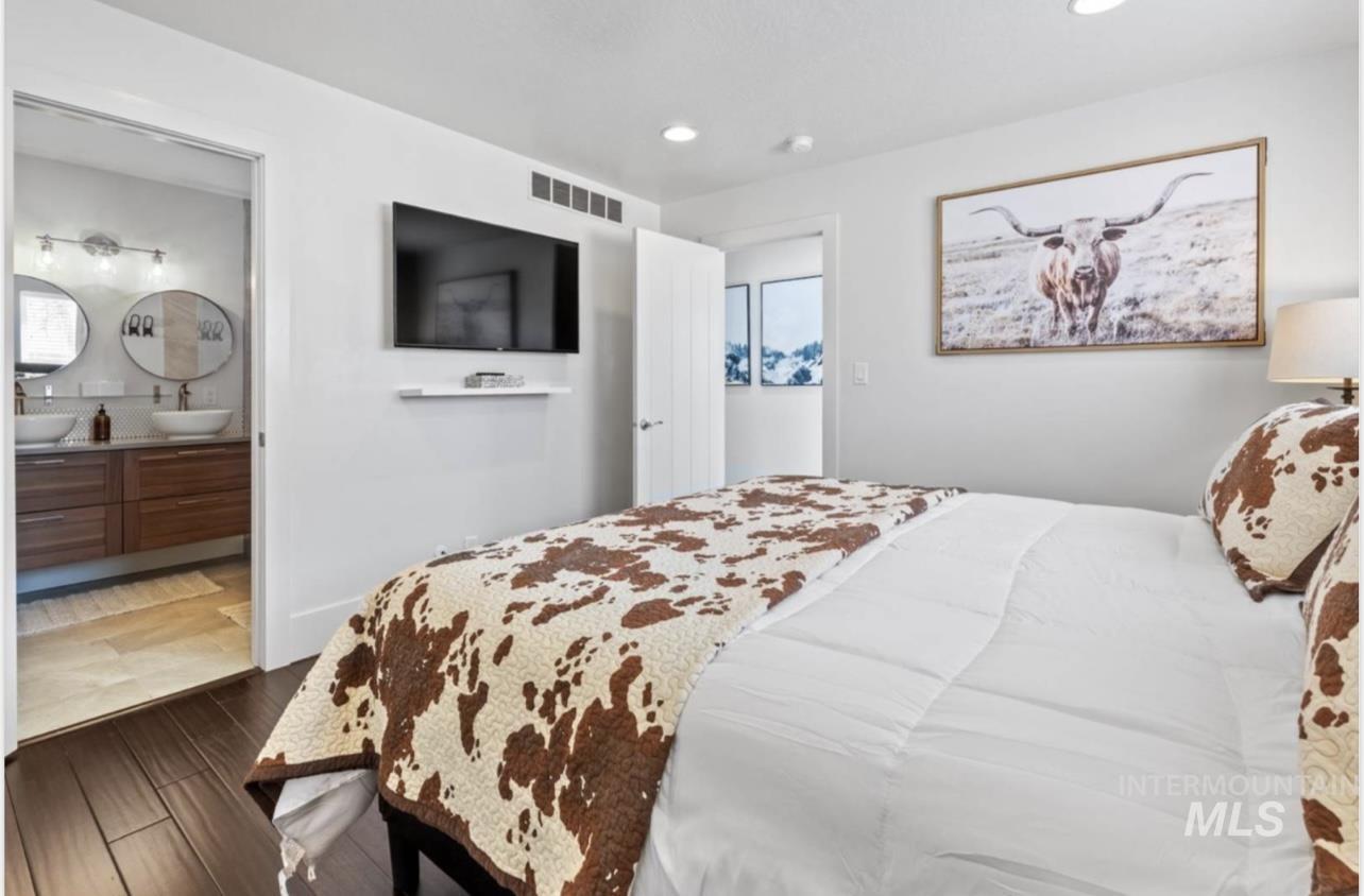 Bedroom featuring wood finished floors, recessed lighting, and ensuite bath