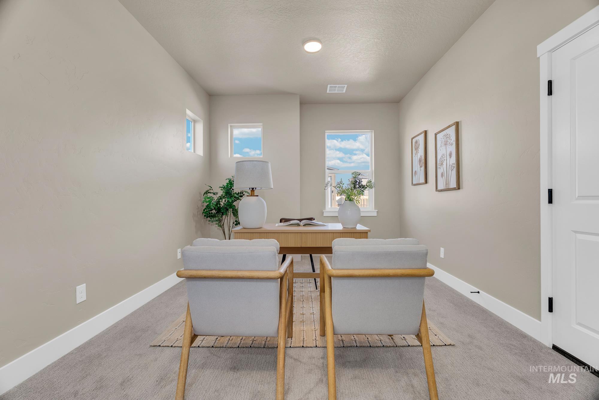 Office featuring light colored carpet and a textured ceiling