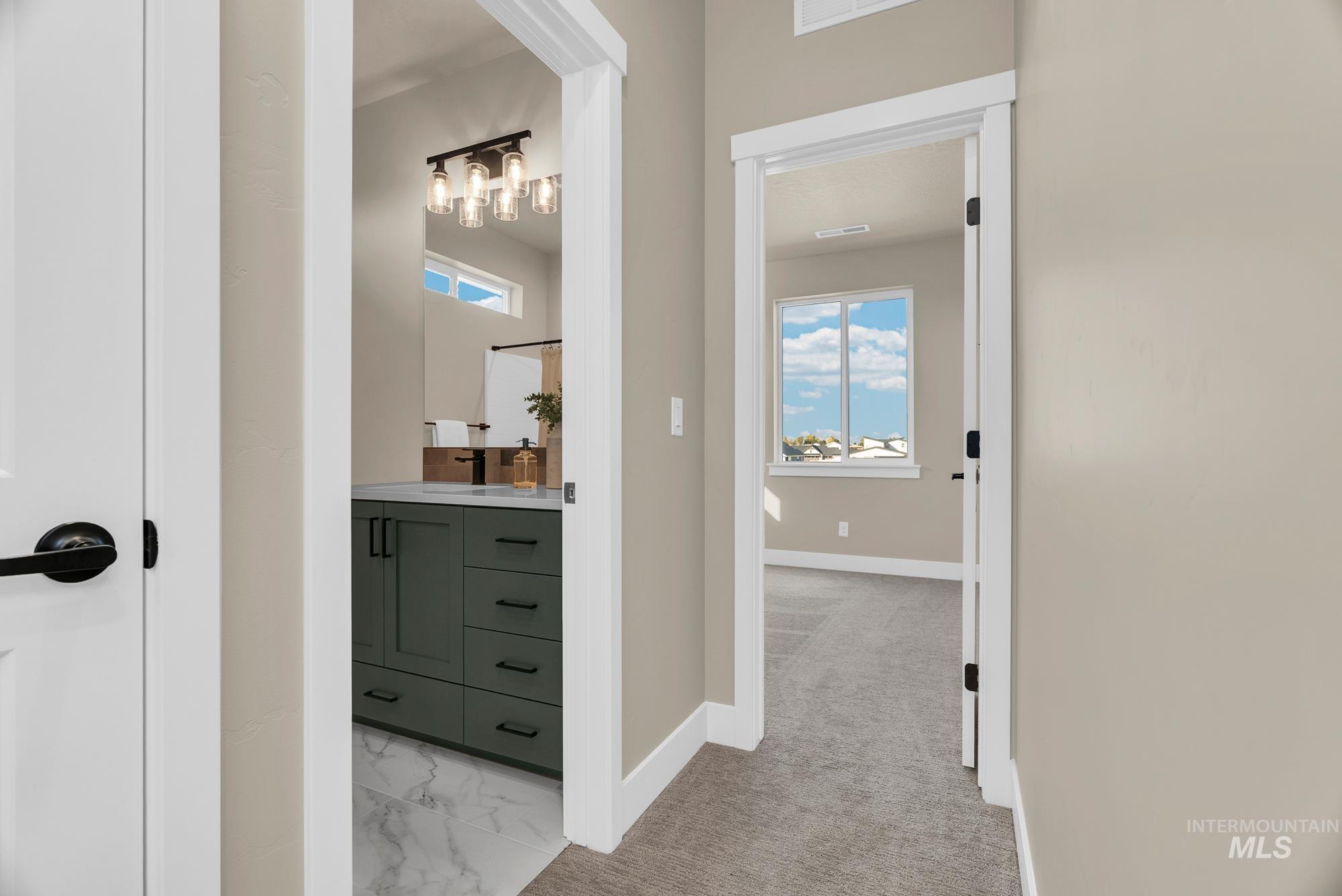 Hall featuring plenty of natural light, light carpet, and light marble finish floors