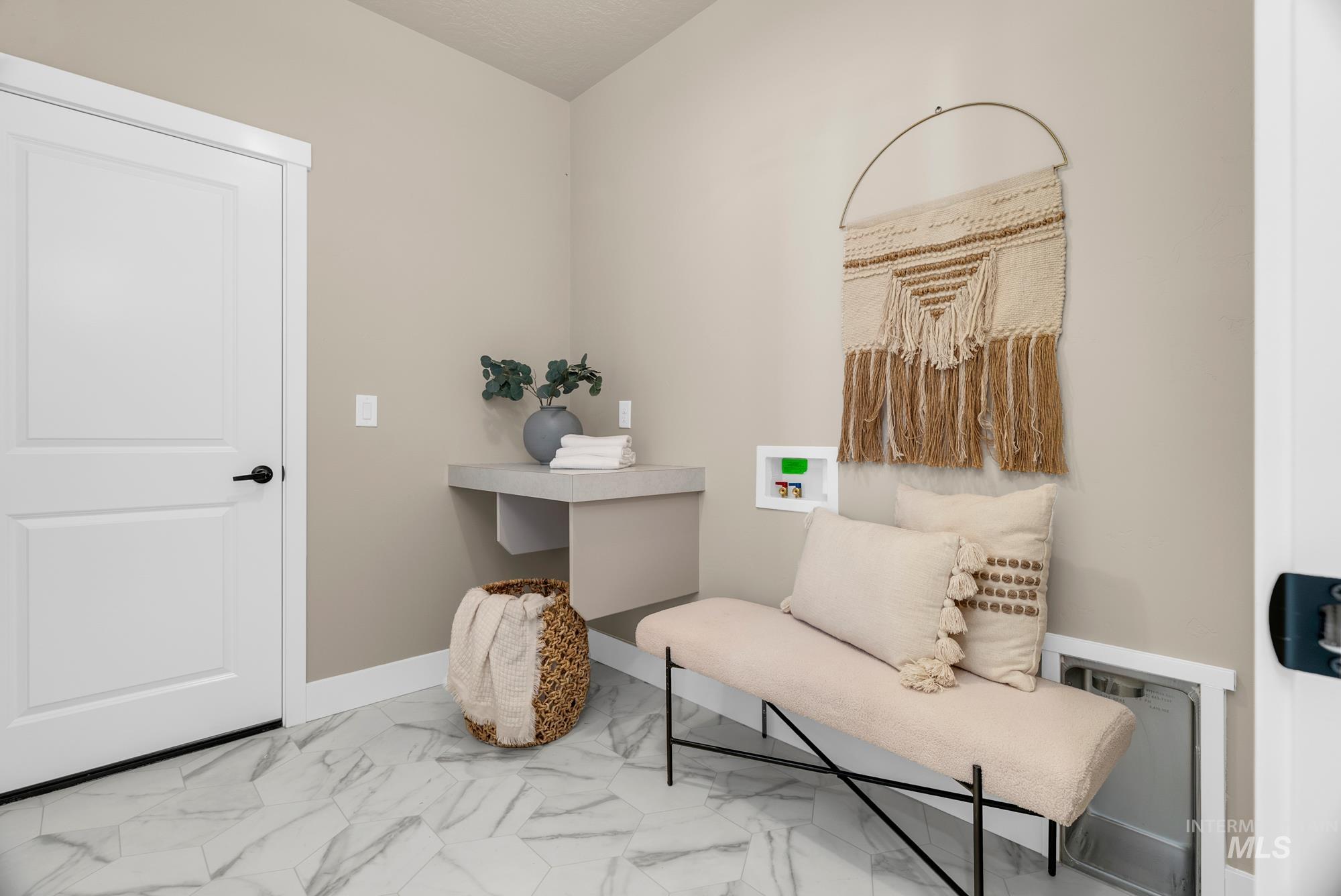 Living area featuring baseboards and light marble finish flooring