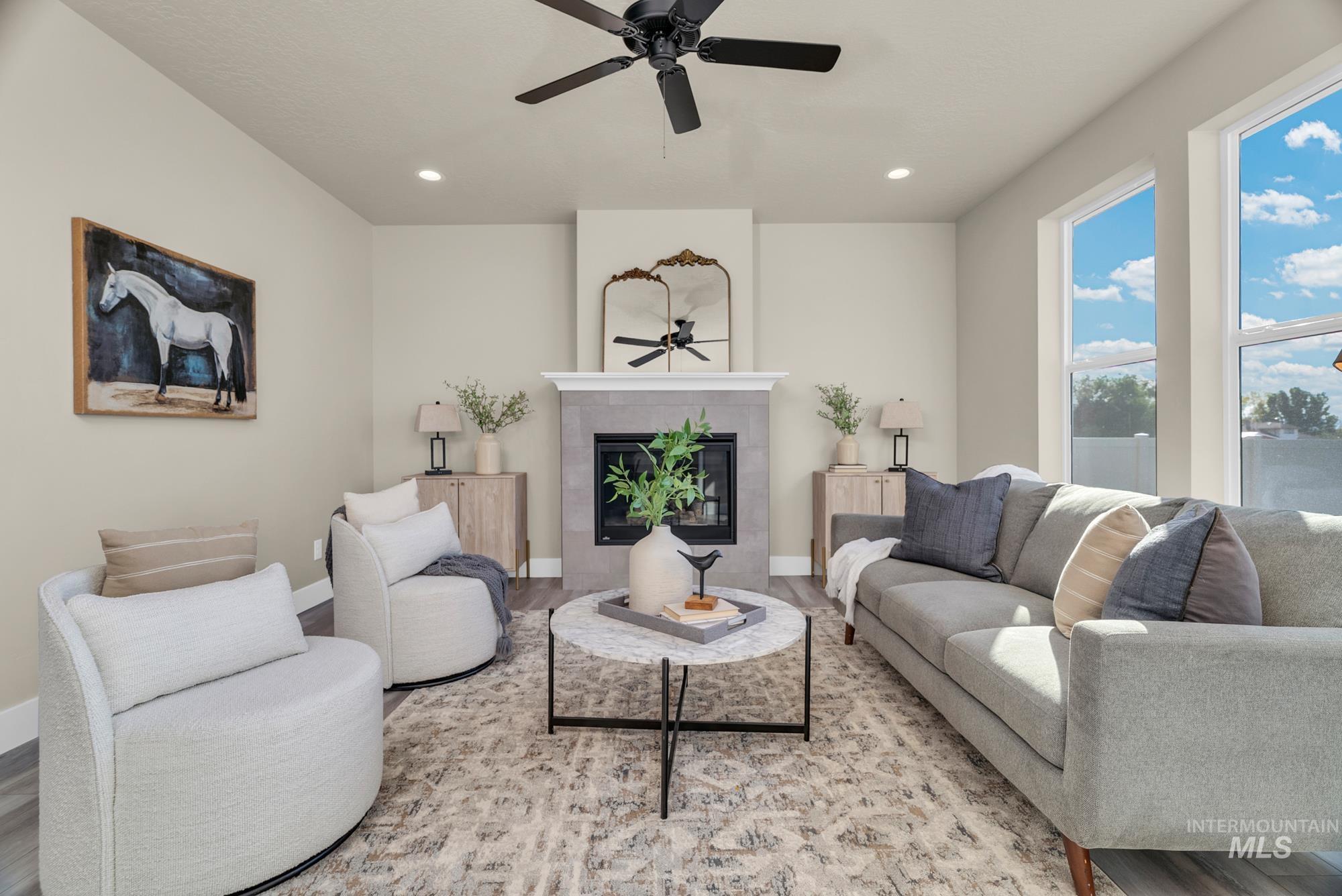 Living area featuring a fireplace, a ceiling fan, recessed lighting, and wood finished floors