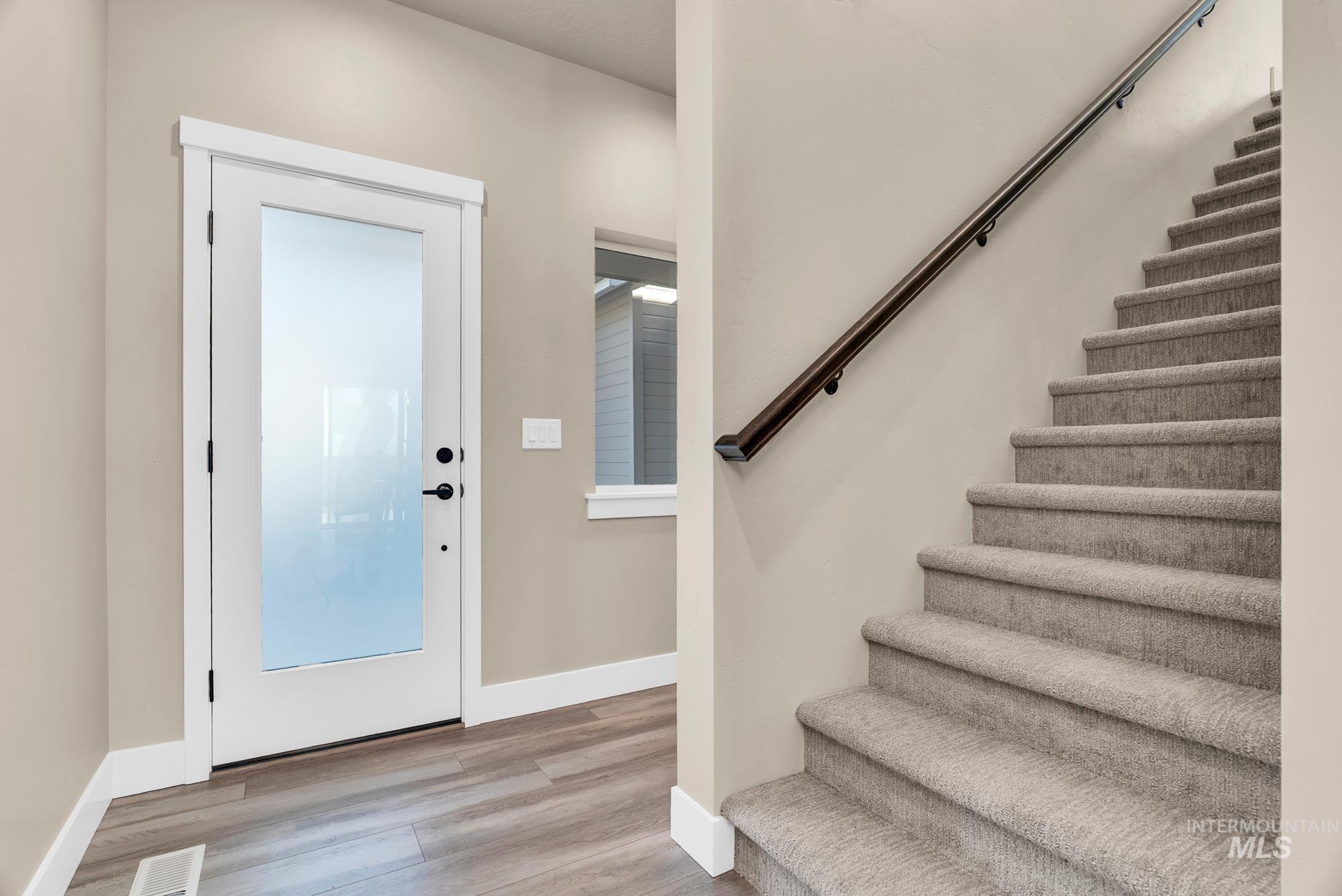 Foyer featuring stairs and light wood-style flooring