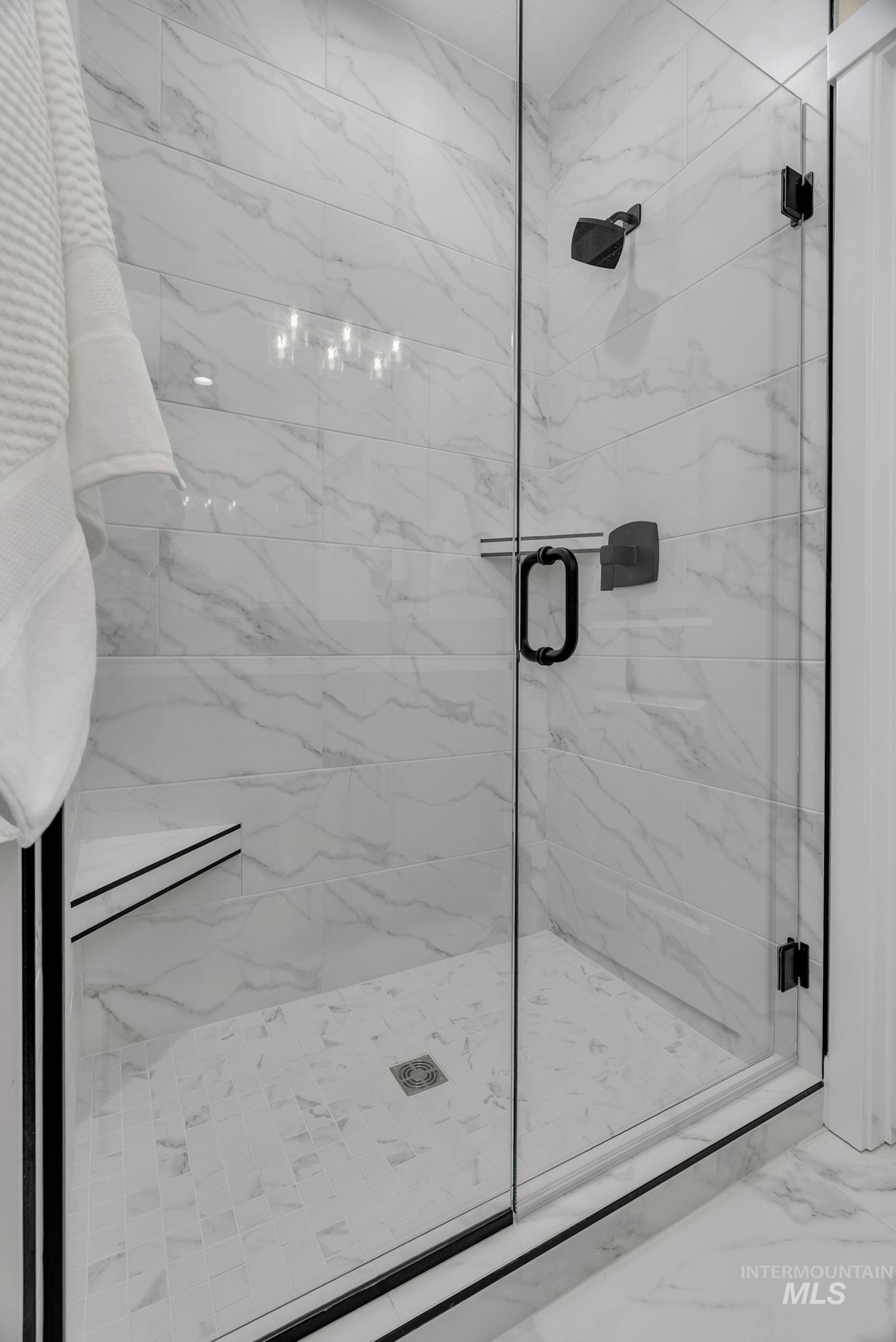 Bathroom featuring a marble finish shower and marble finish floors