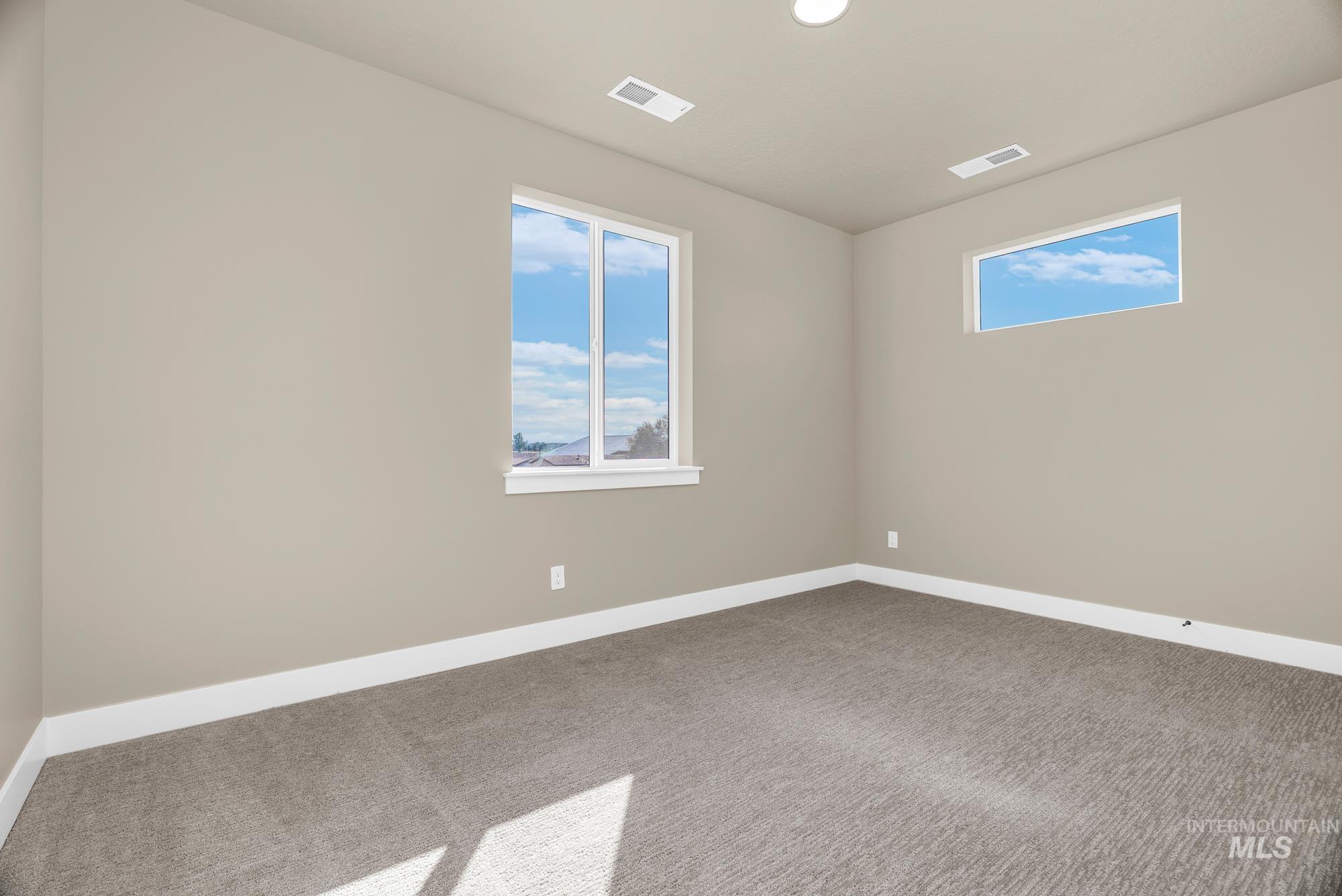 Carpeted spare room with baseboards and recessed lighting