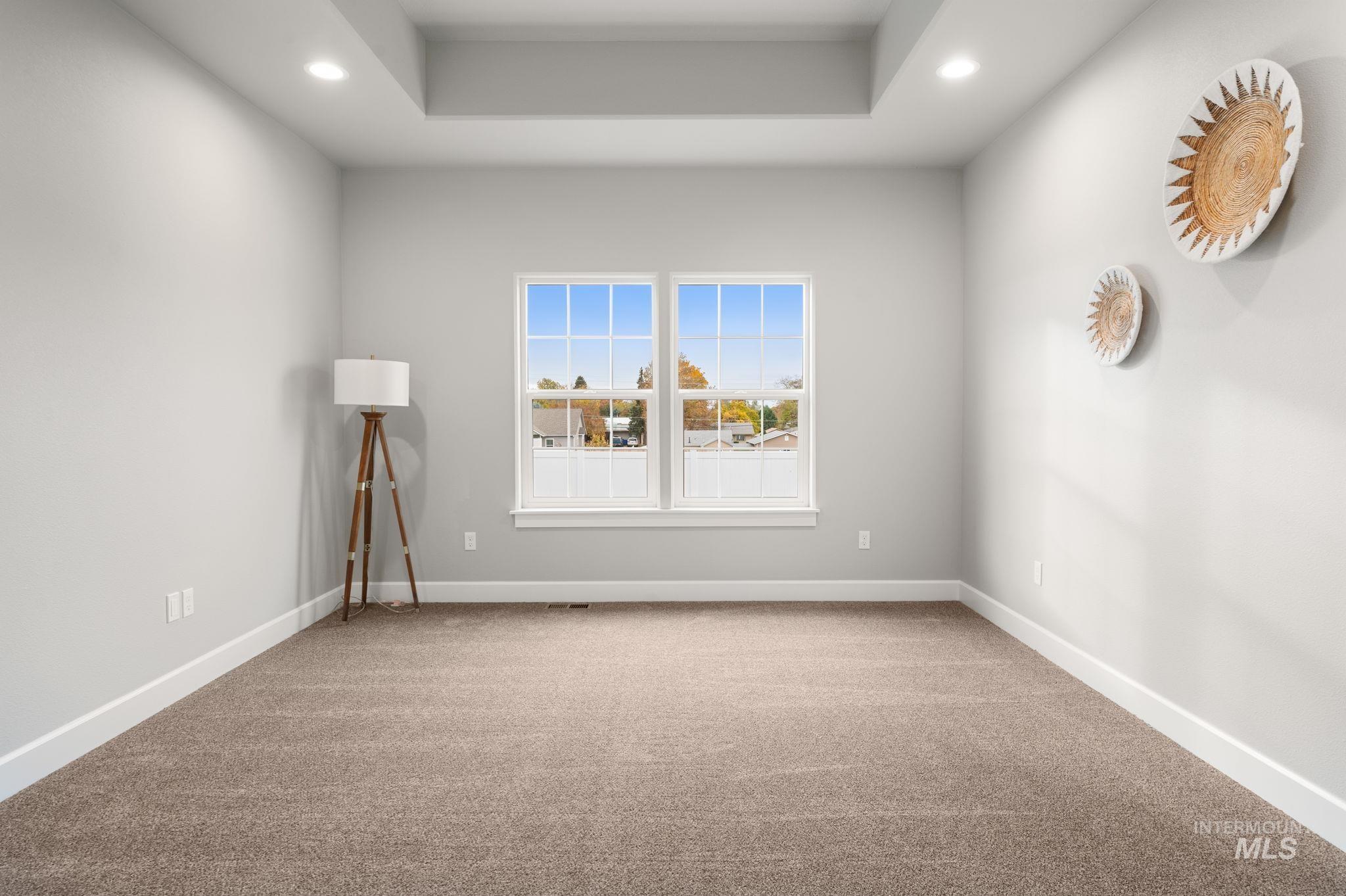Unfurnished room featuring light colored carpet, recessed lighting, and a tray ceiling
