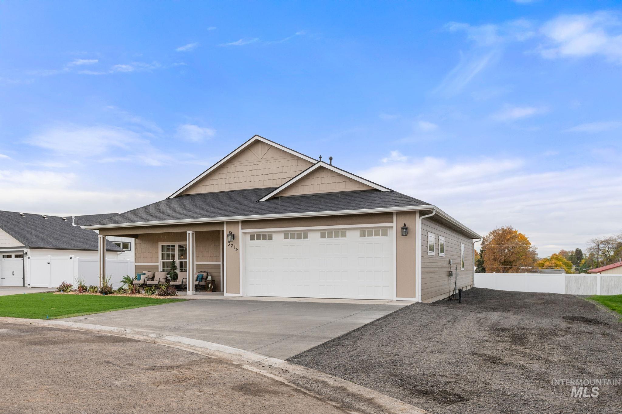 View of front of home with a shingled roof, driveway, an attached garage, and covered porch