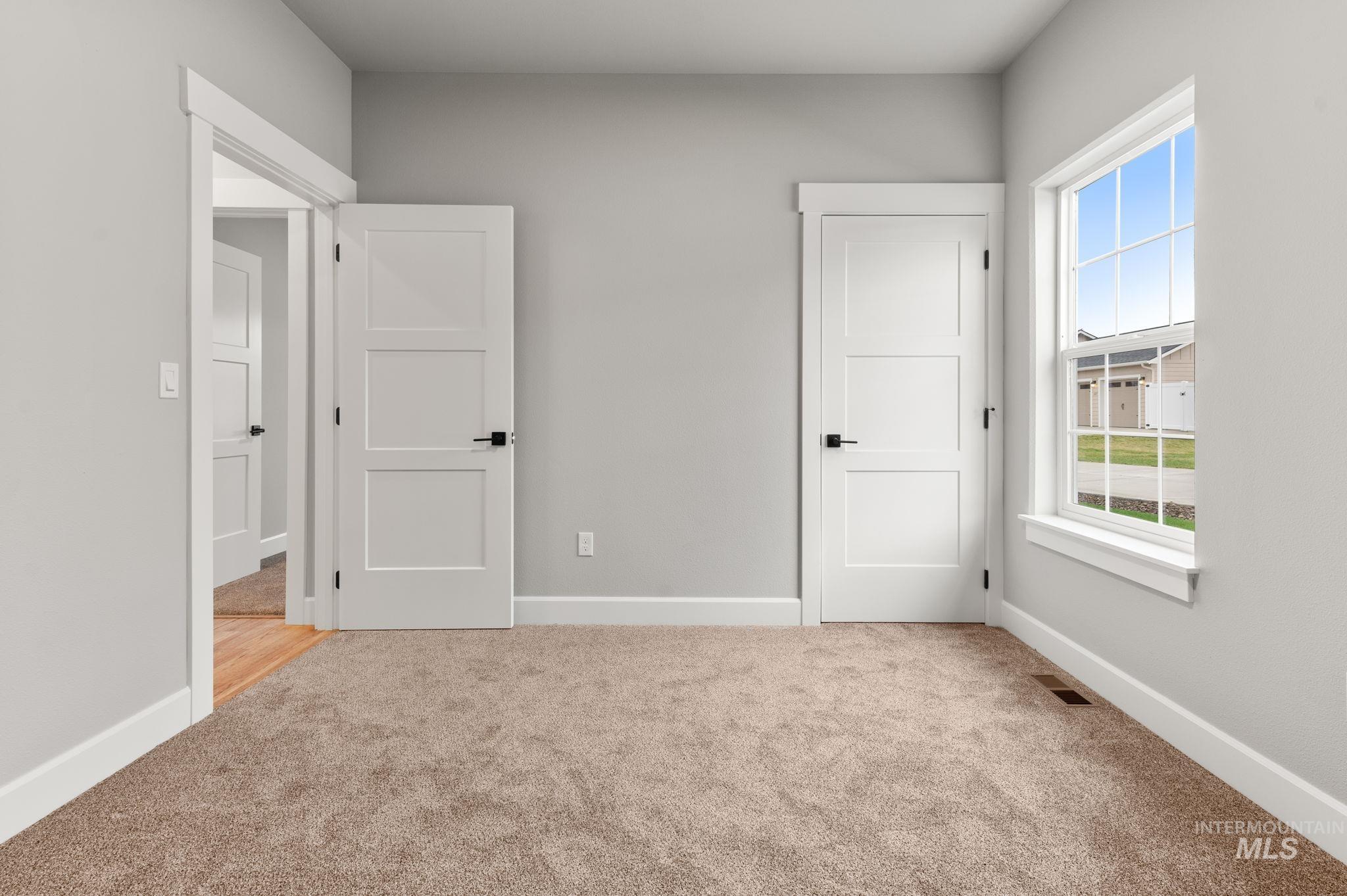 Unfurnished bedroom with carpet floors and baseboards