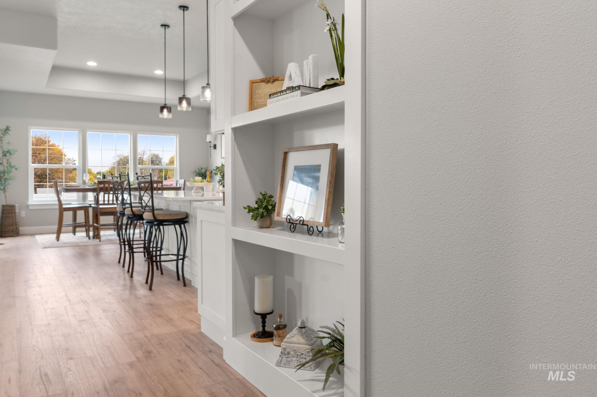 Hallway with light wood-type flooring and built in features