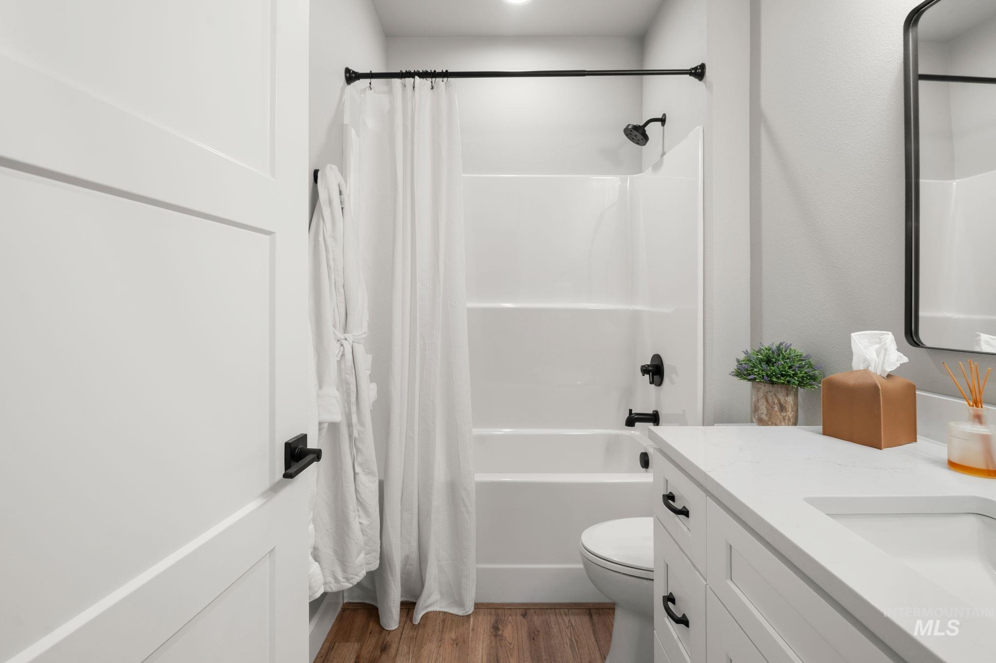 Full bathroom featuring light wood-style flooring, shower / tub combo, and vanity