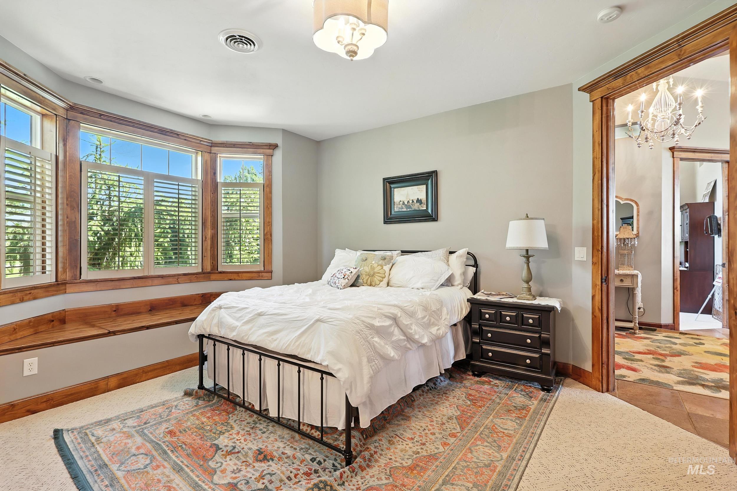 Bedroom with a chandelier and baseboards