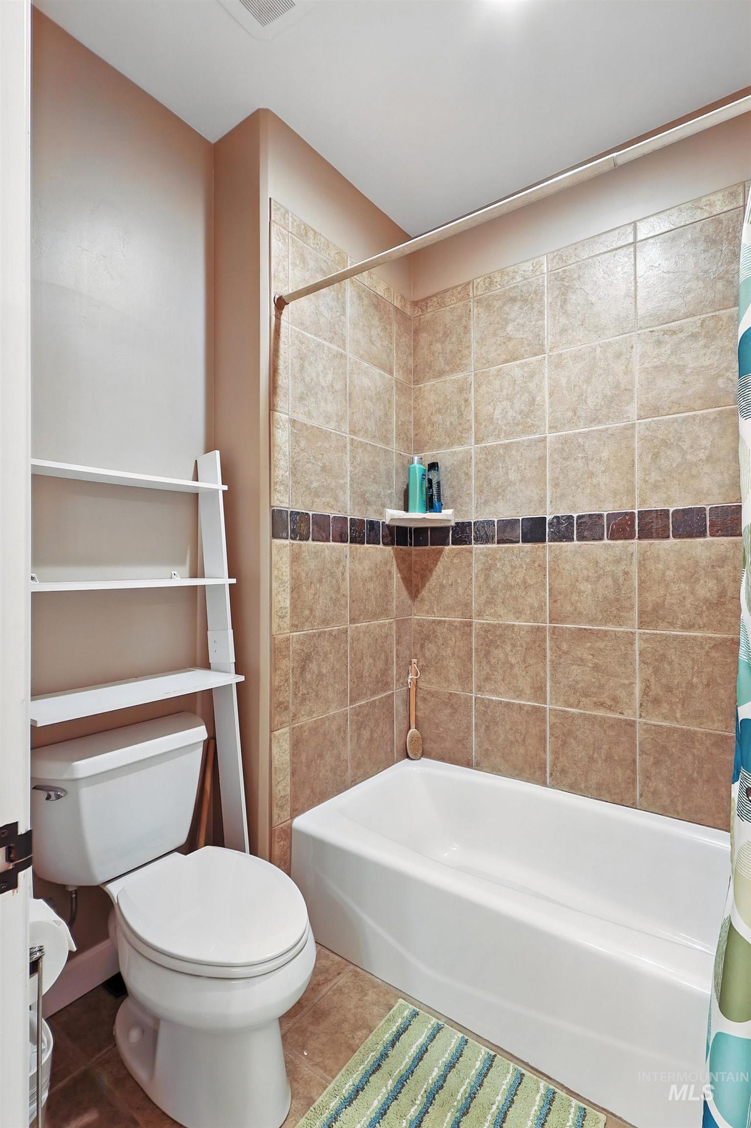 Bathroom with tile patterned floors and shower / bathtub combination with curtain