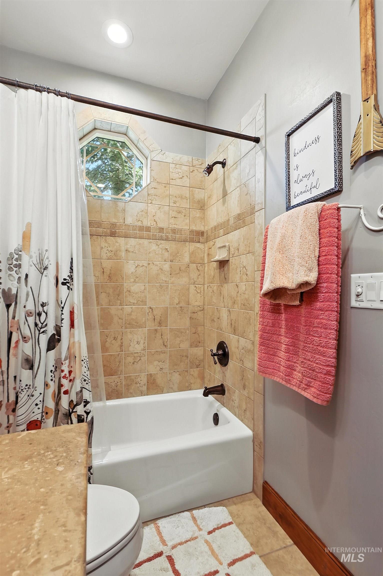 Bathroom featuring shower / bath combination with curtain and tile patterned floors