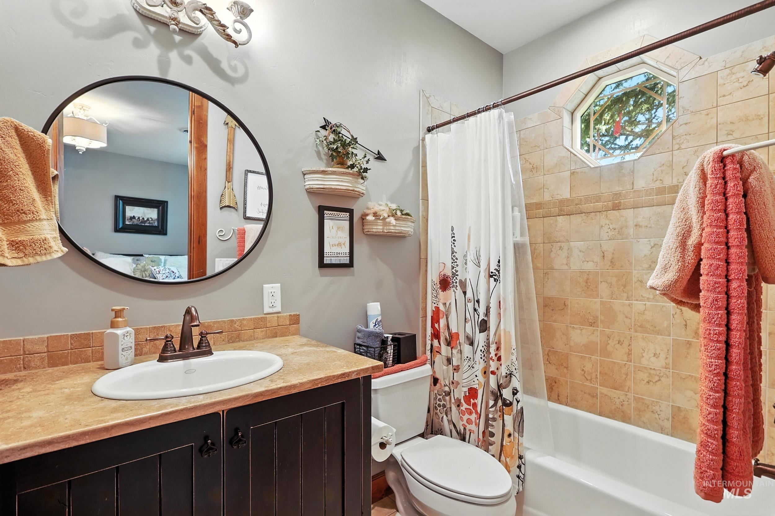 Bathroom with shower / bathtub combination with curtain and vanity