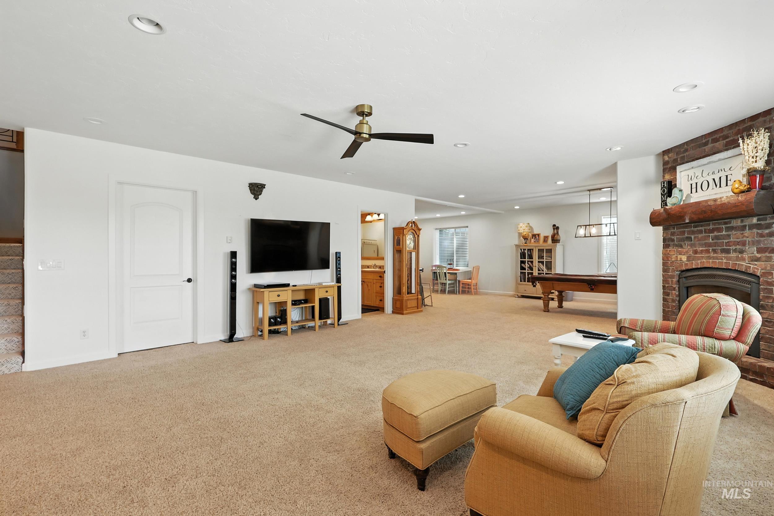 Living area featuring pool table, light carpet, recessed lighting, a fireplace, and ceiling fan