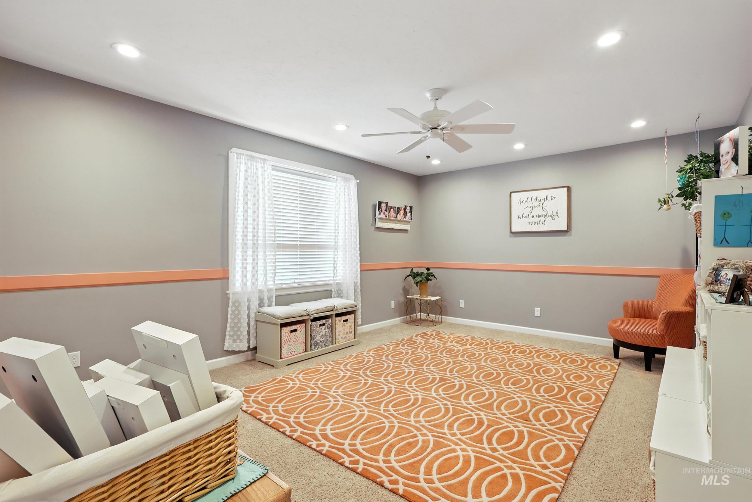 Living area with light colored carpet, recessed lighting, and a ceiling fan
