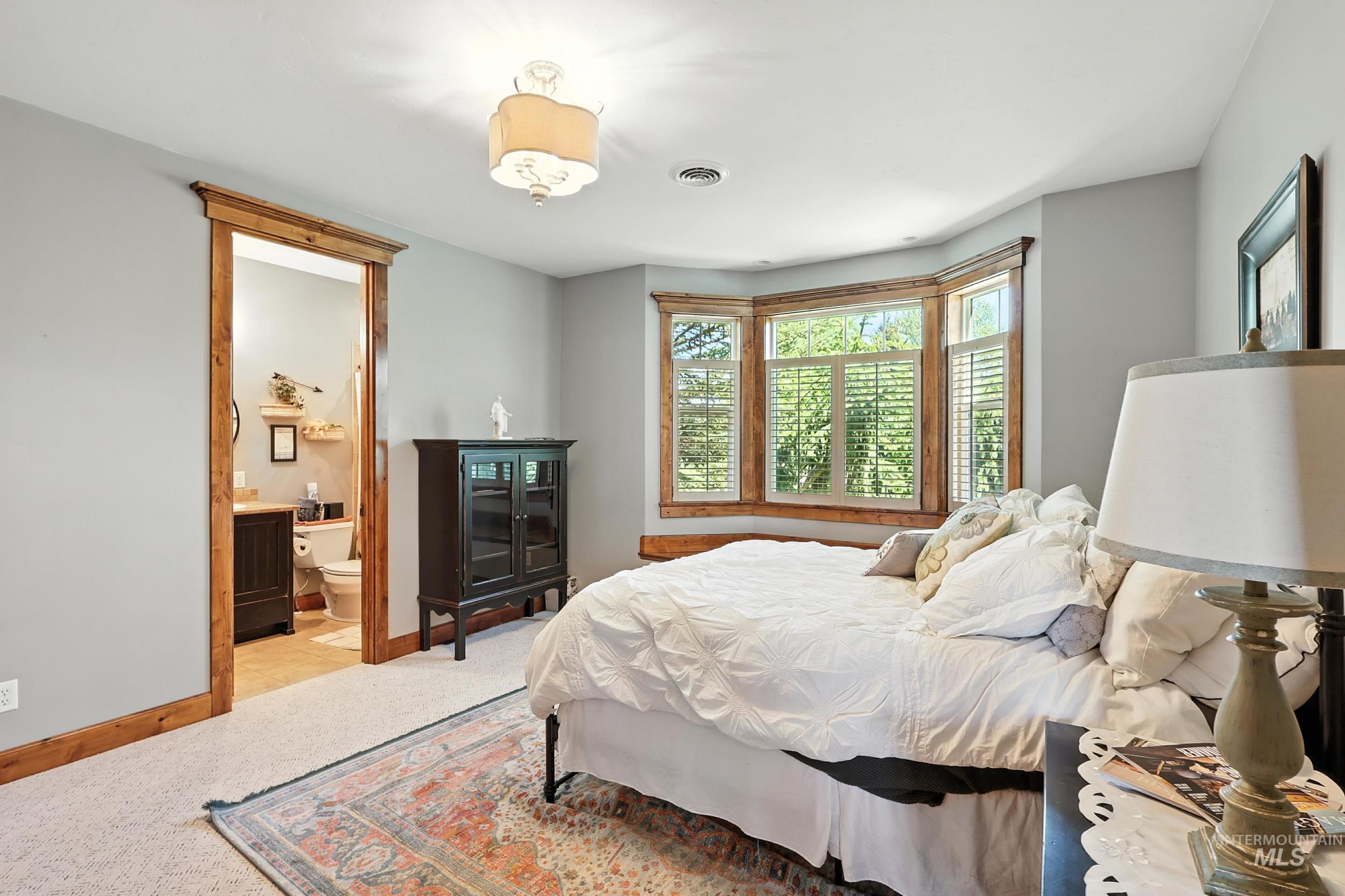 Bedroom featuring connected bathroom and carpet flooring