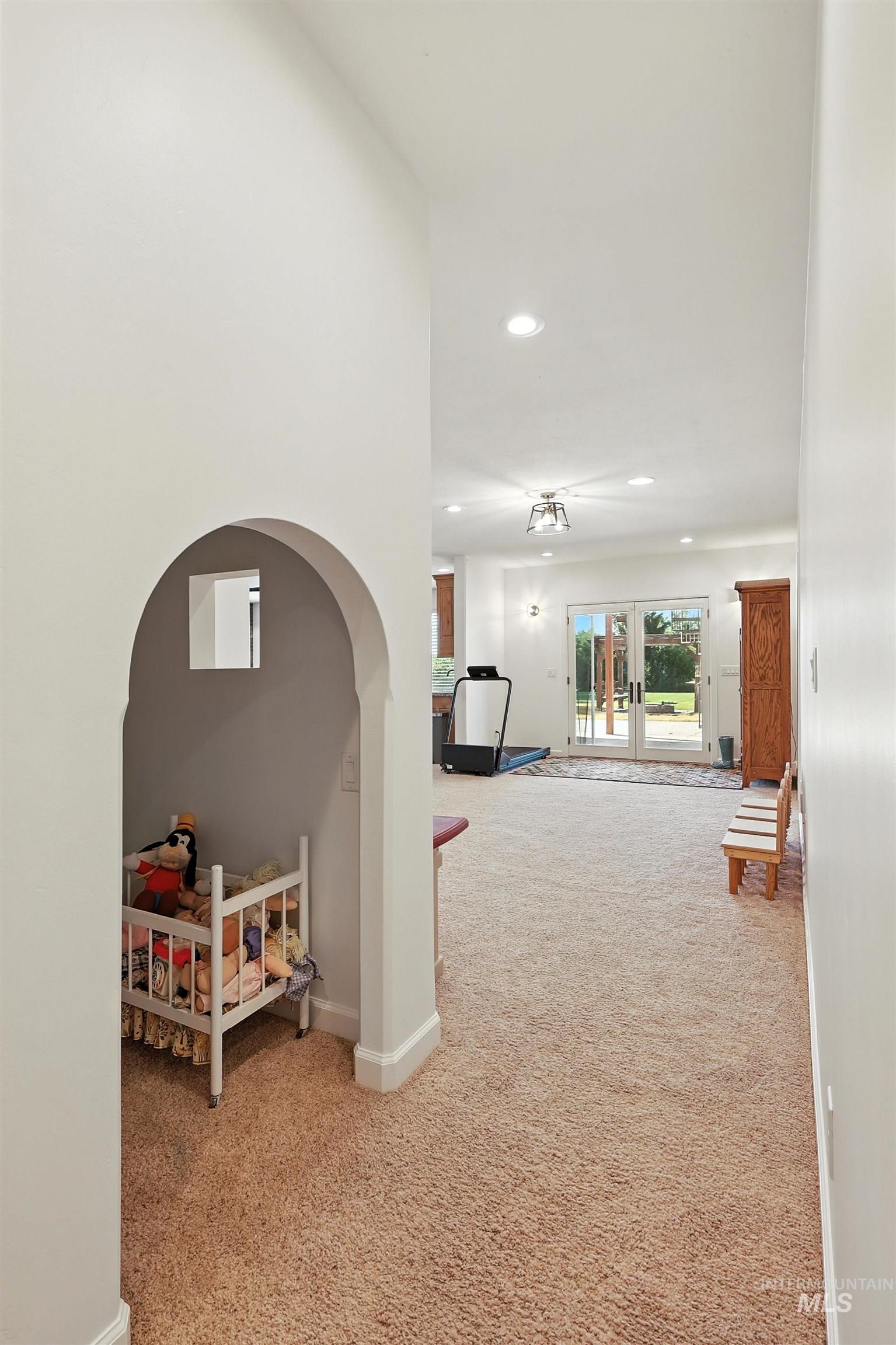 Hall featuring light colored carpet, recessed lighting, and french doors
