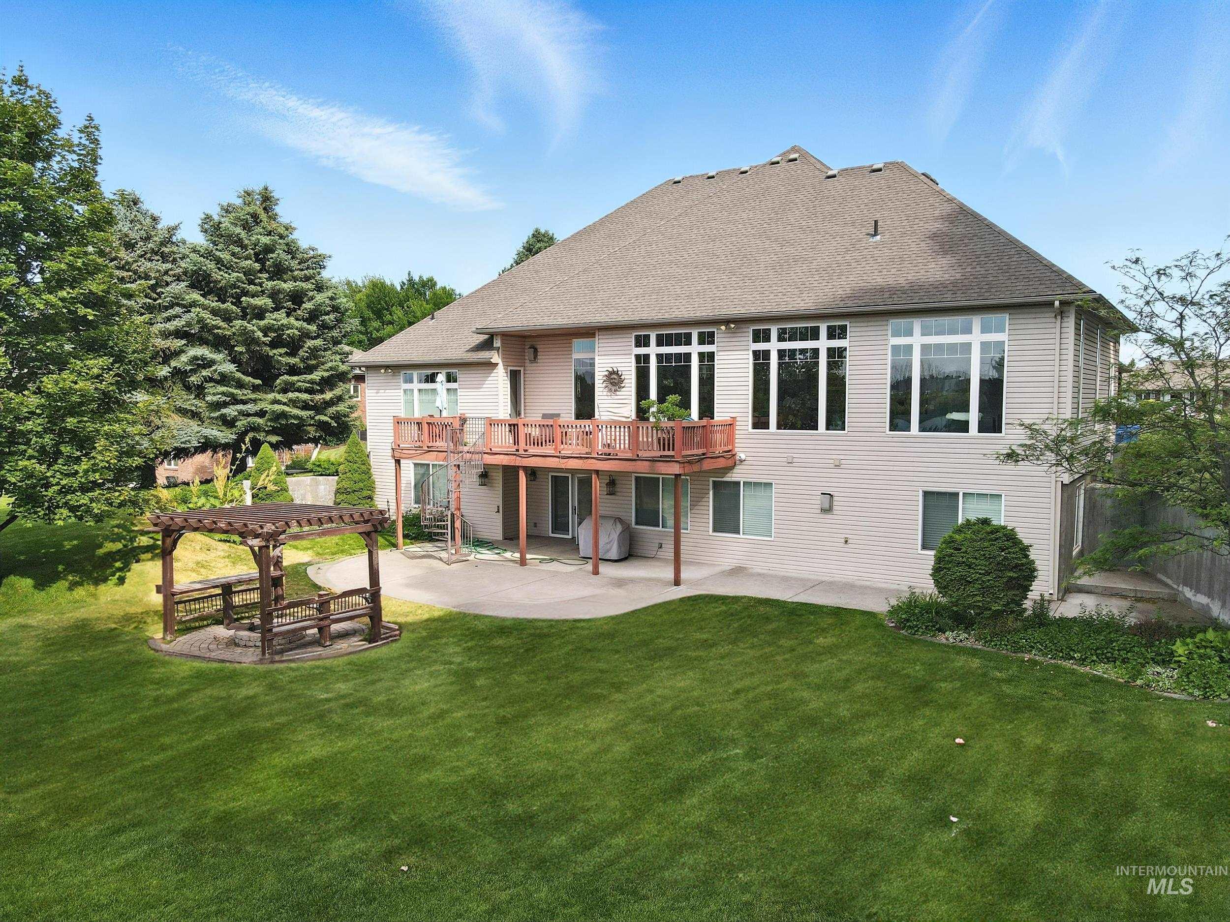 Rear view of house with a patio area, a yard, a shingled roof, and a wooden deck