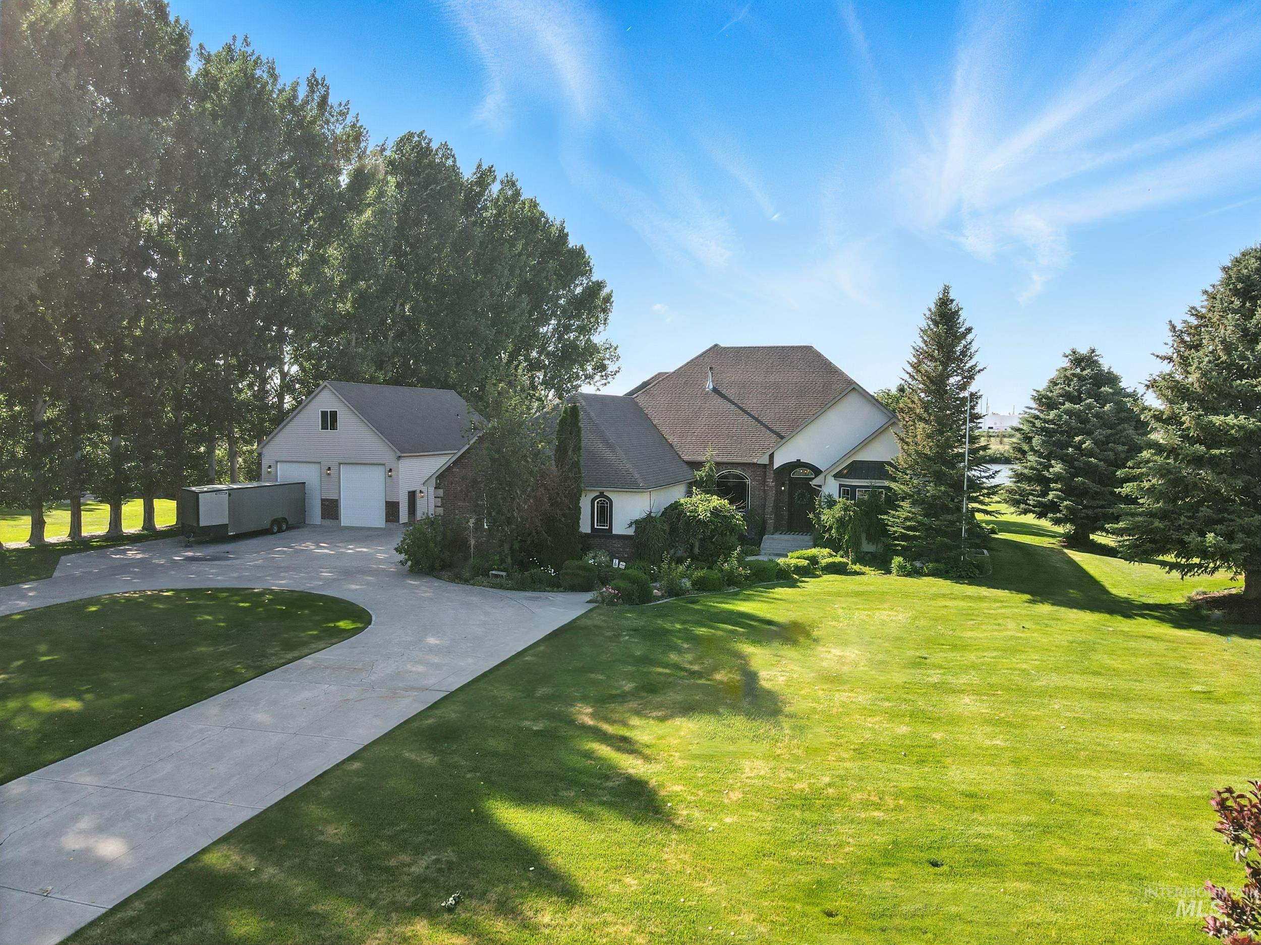 View of front of home featuring a garage, a front yard, and driveway