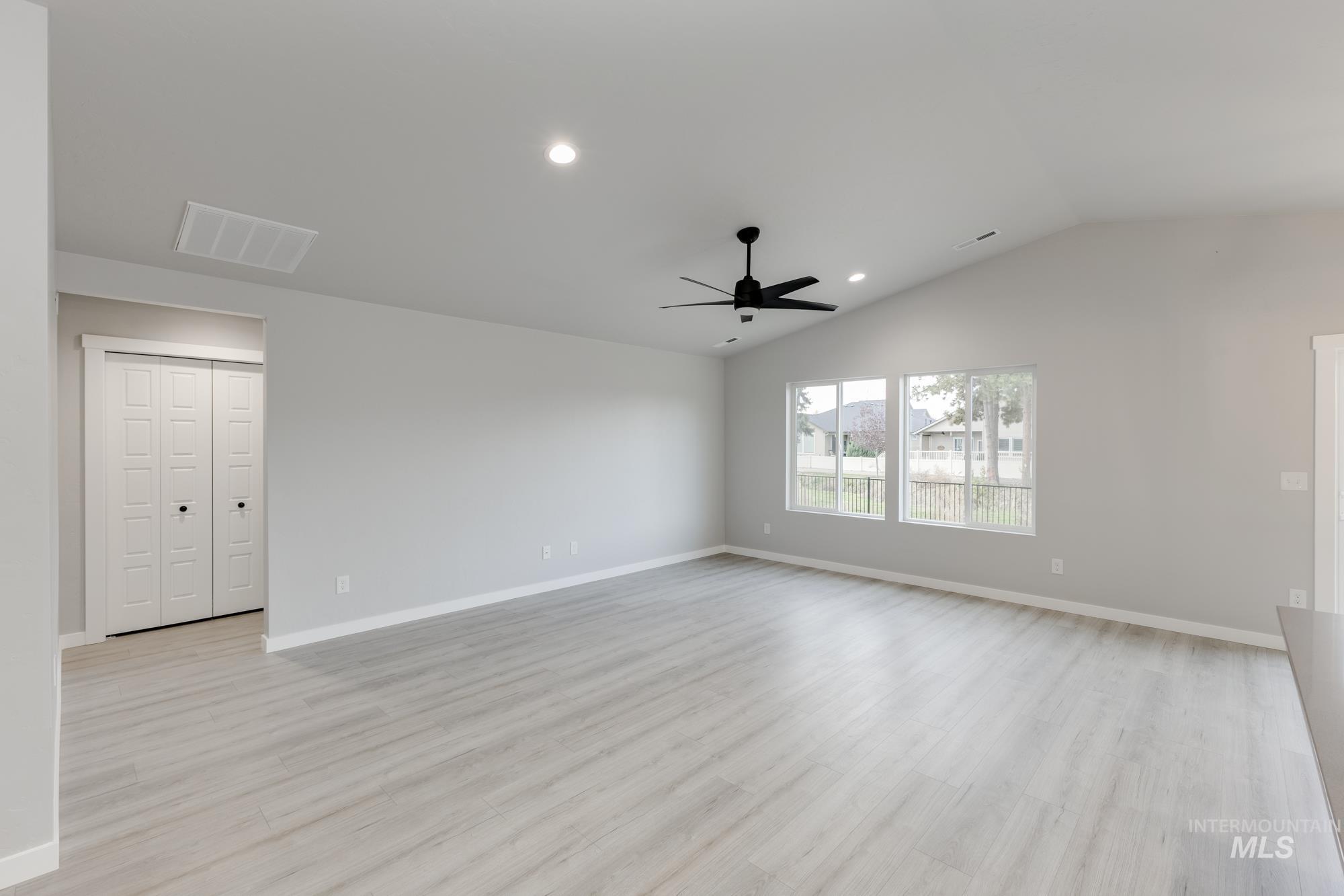 Unfurnished room with light wood finished floors, recessed lighting, vaulted ceiling, and a ceiling fan