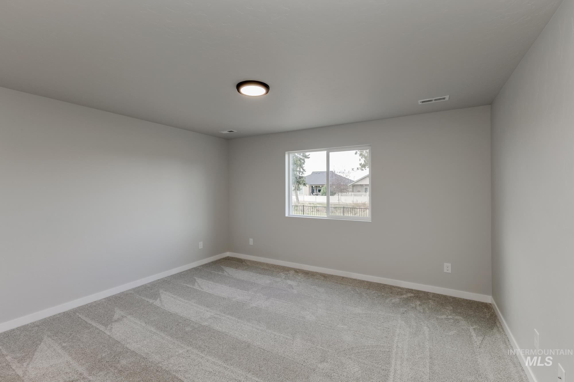 Carpeted spare room with baseboards